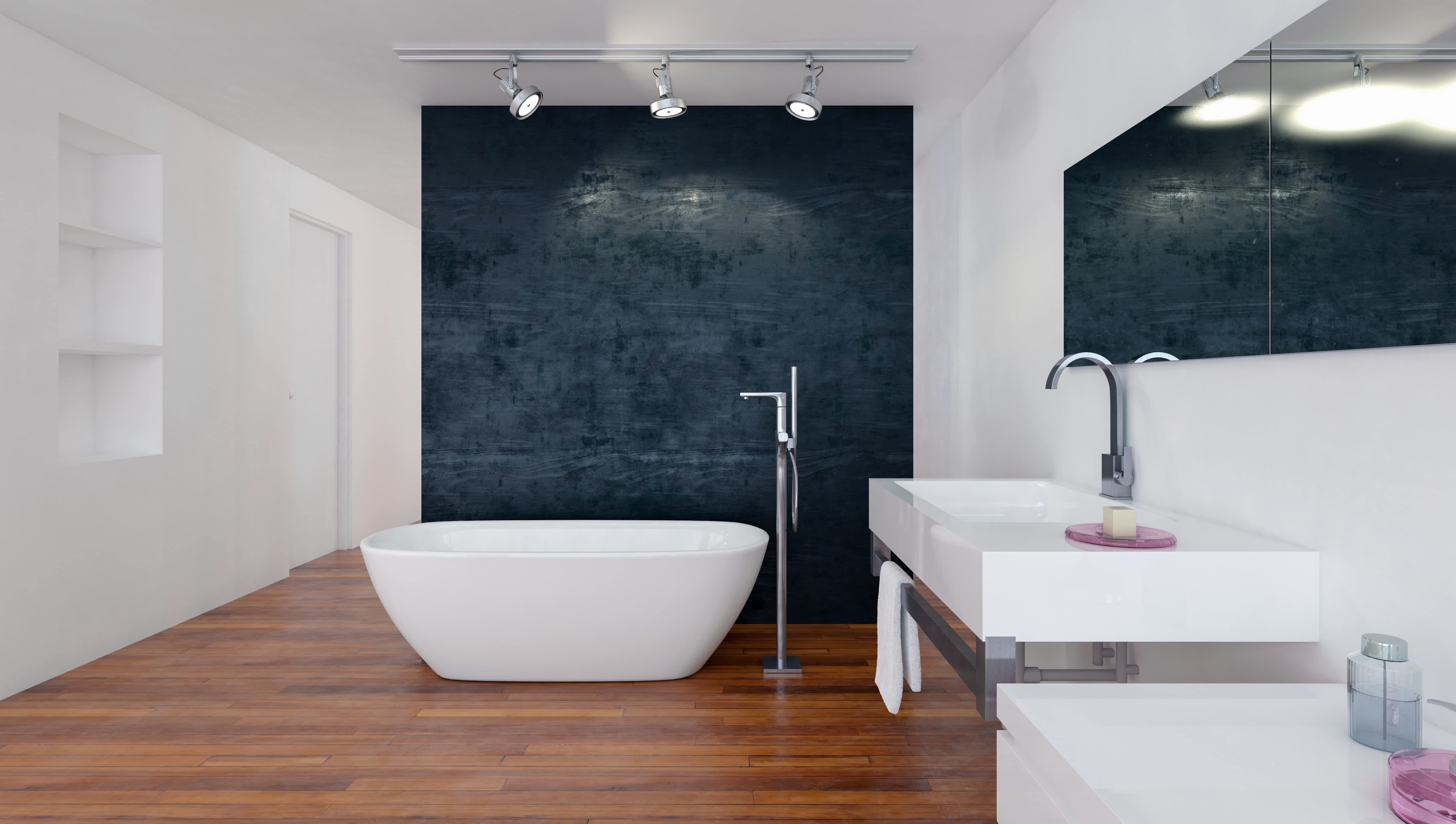 Modern bathroom with wood floors, white tub, and black wallpaper accent wall