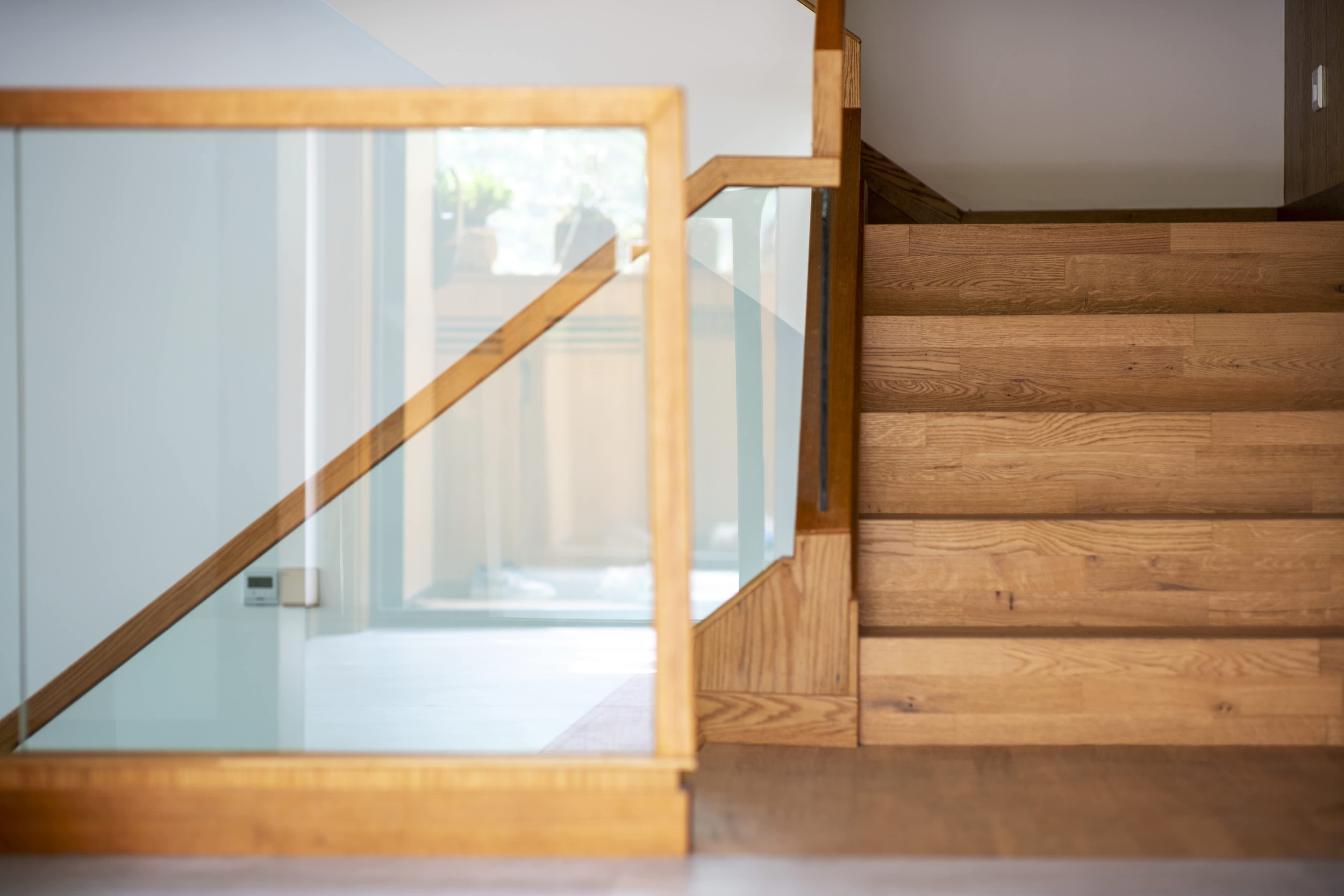 Glass balustrade panels on modern wooden staircase