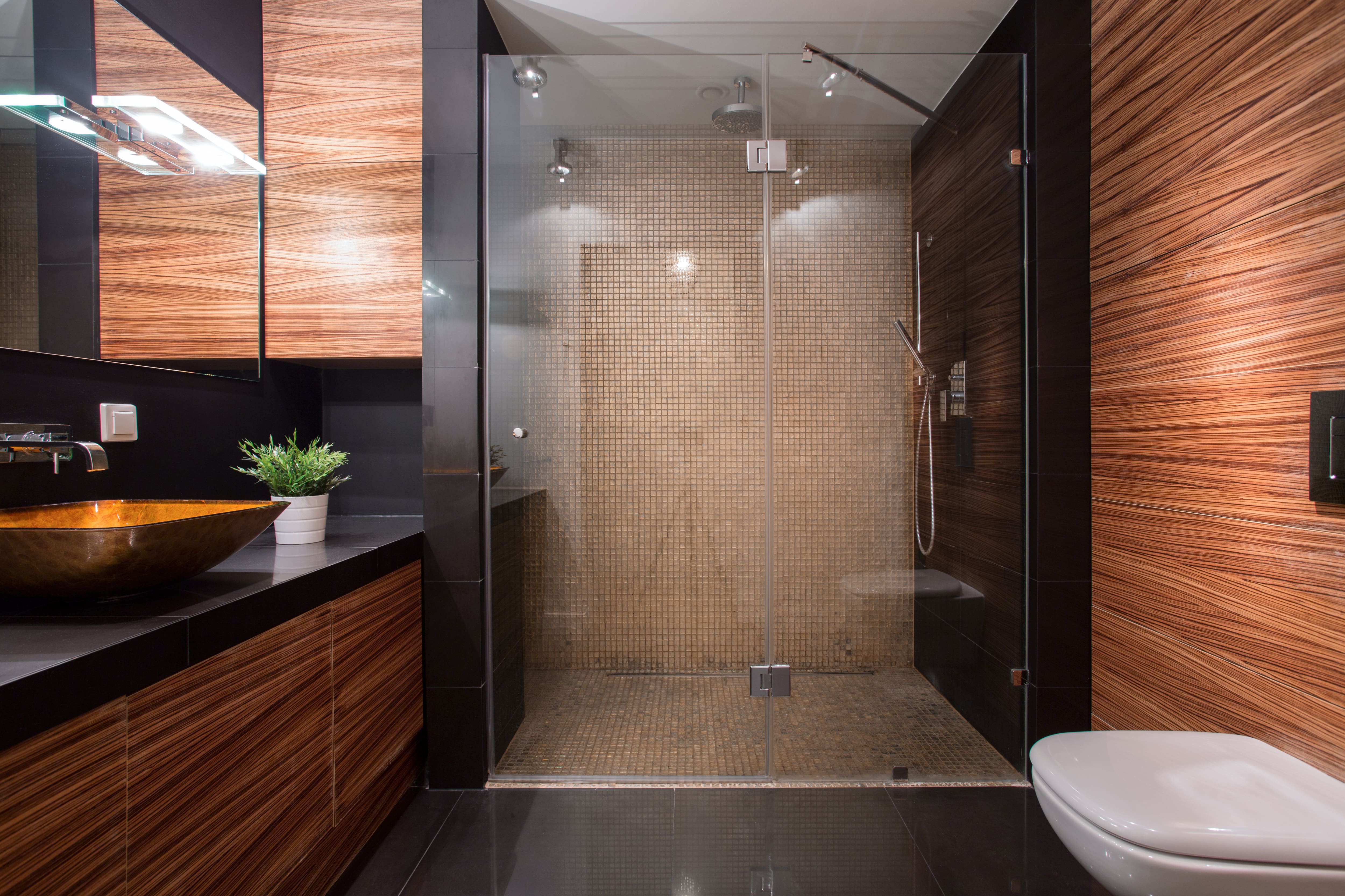 Modern bathroom with wood paneling, large shower, and black tile backsplash