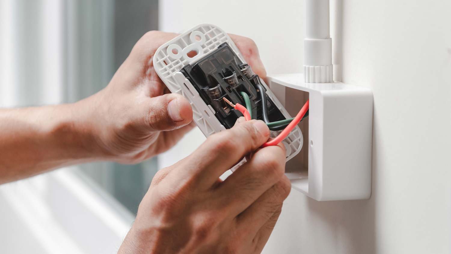 Detail of a man’s hand installing an outlet