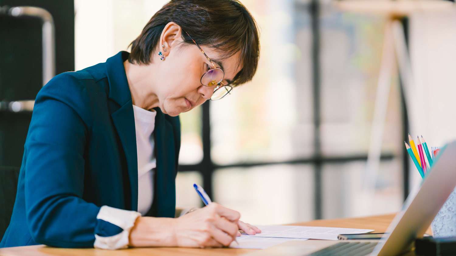 A senior woman filling the paperwork for a home loan