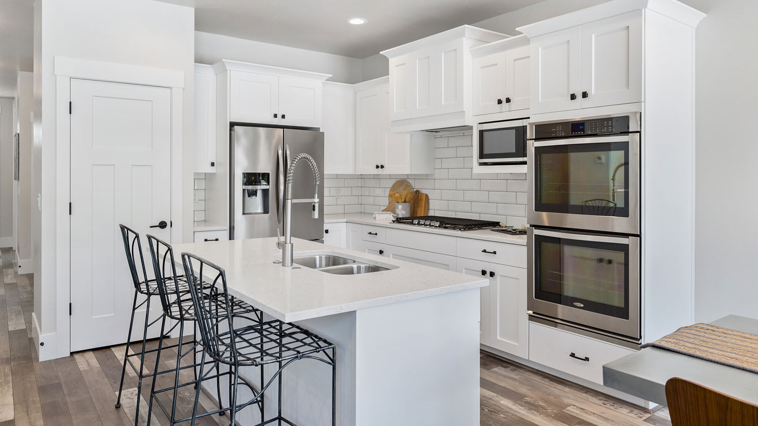 White kitchen with black hardware and stainless-steel appliances
