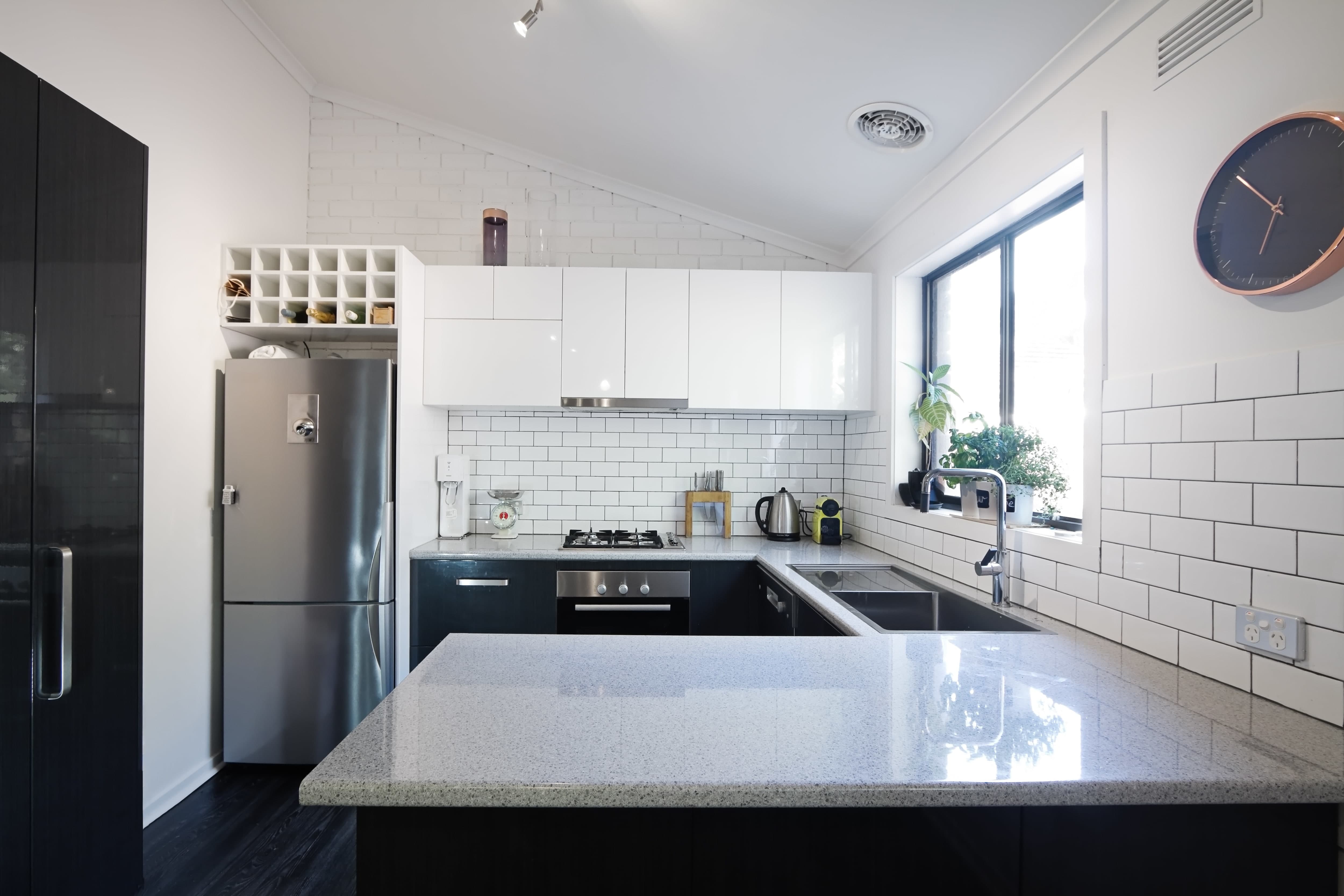 Small white kitchen with white subway tile and black grout