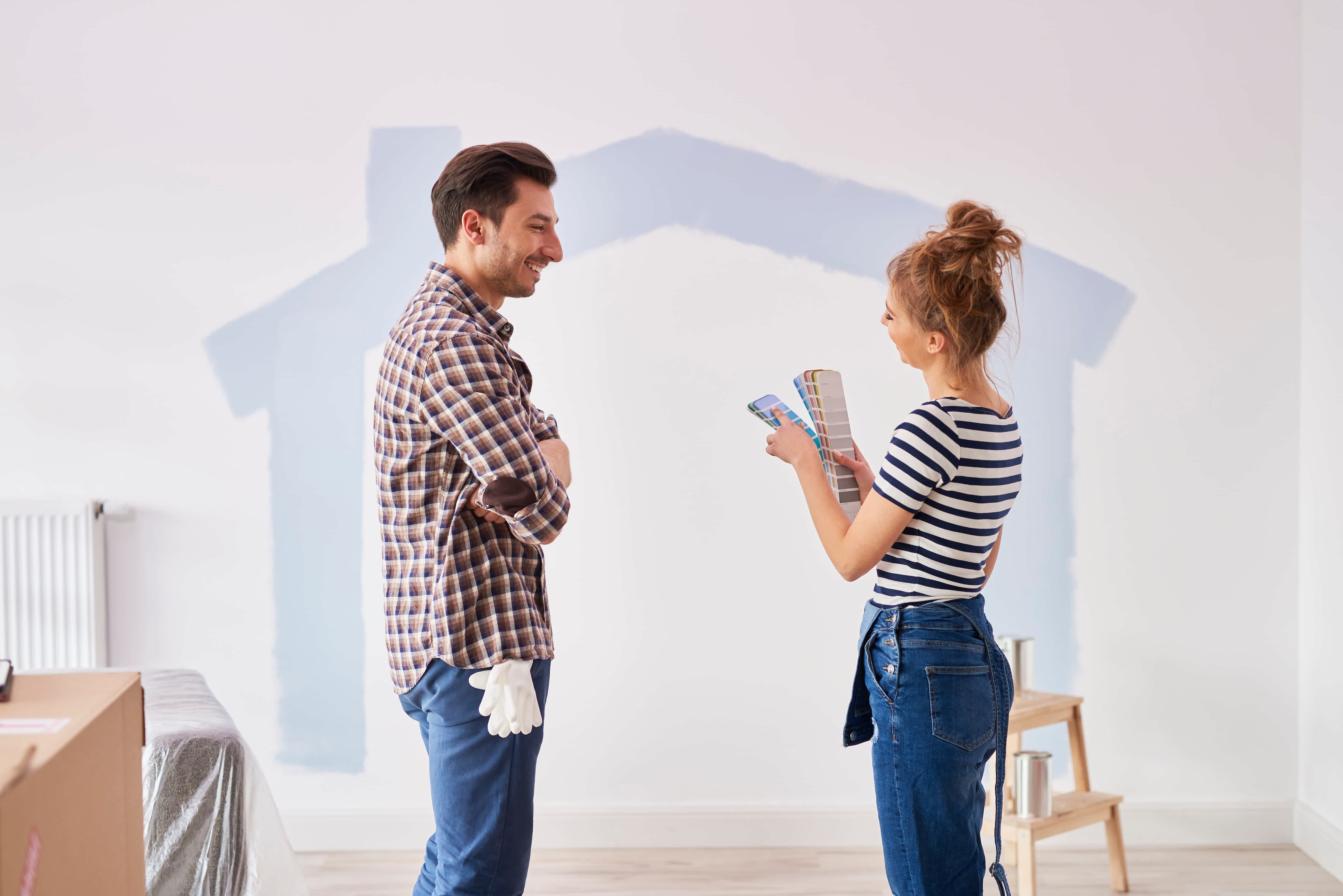 A couple looks at paint options in their new apartment