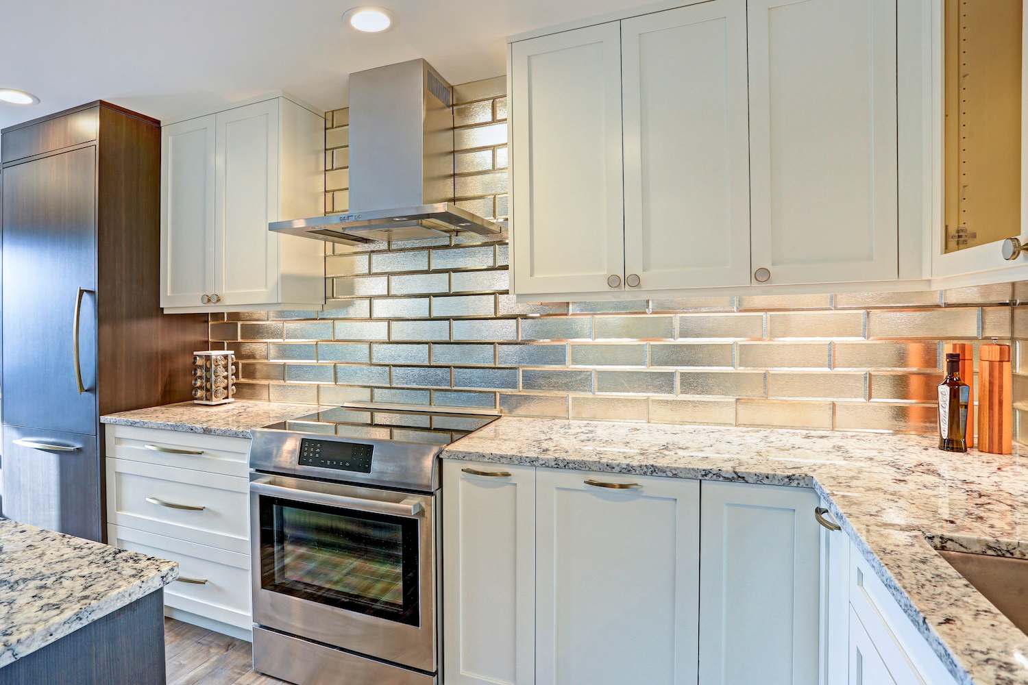 Kitchen with stainless subway tile backsplash and white cabinets