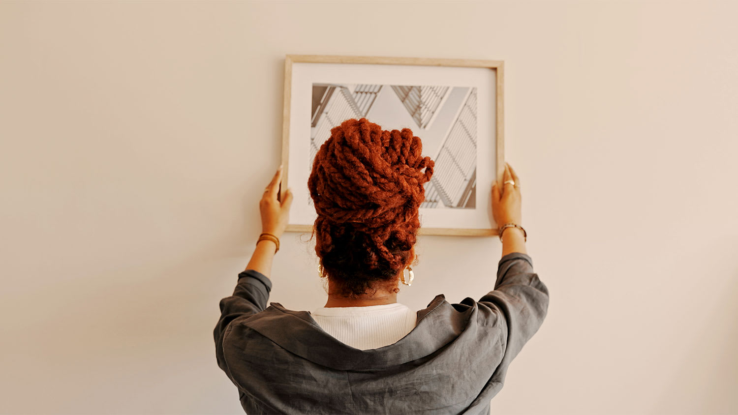 A woman moves a picture frame