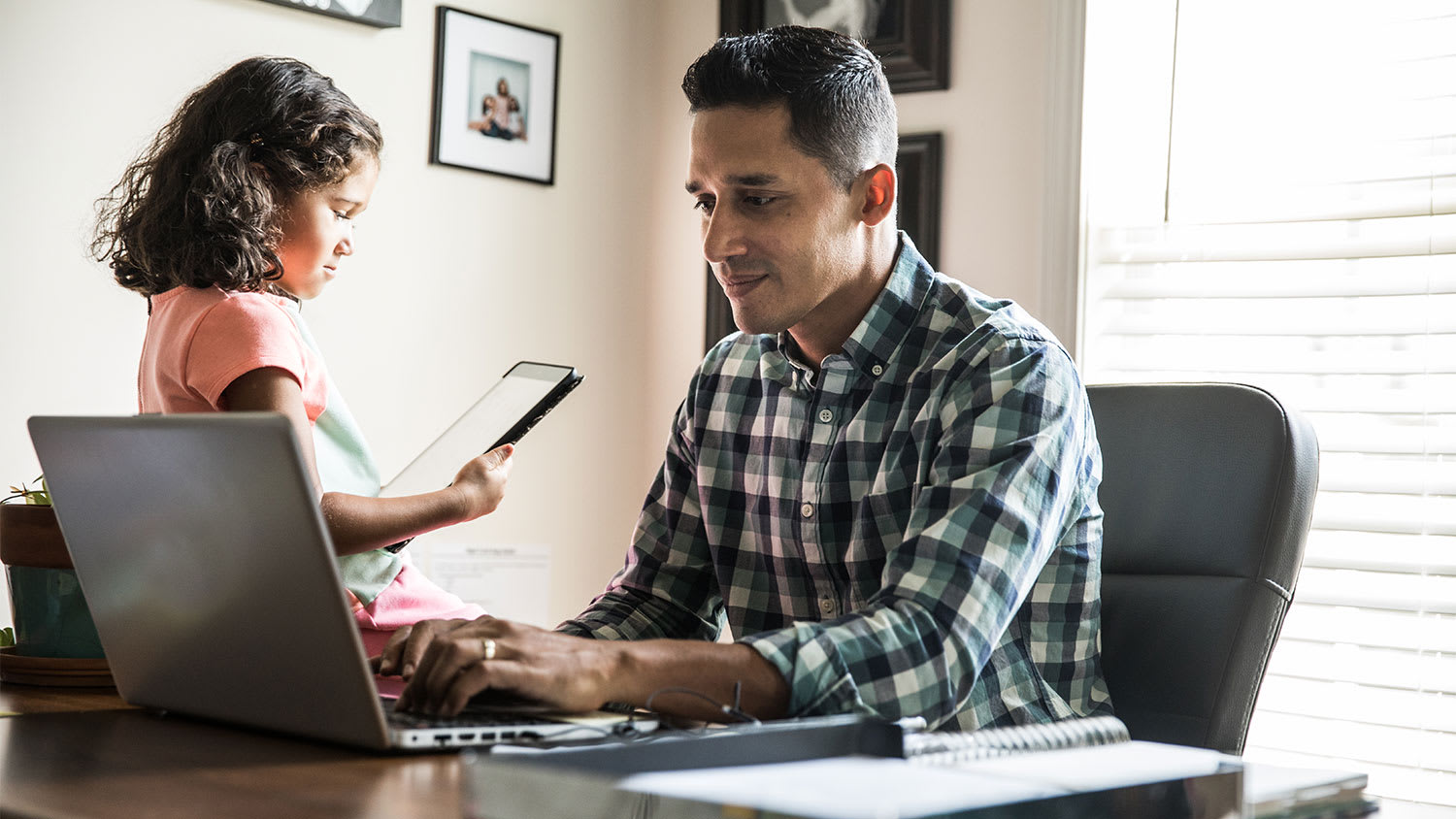 A father and daughter at a computer in a study