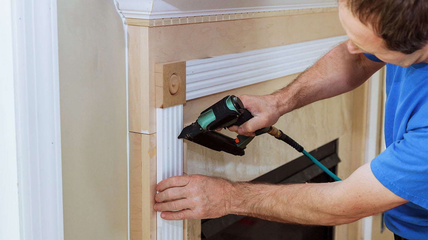 man replacing fireplace moldings