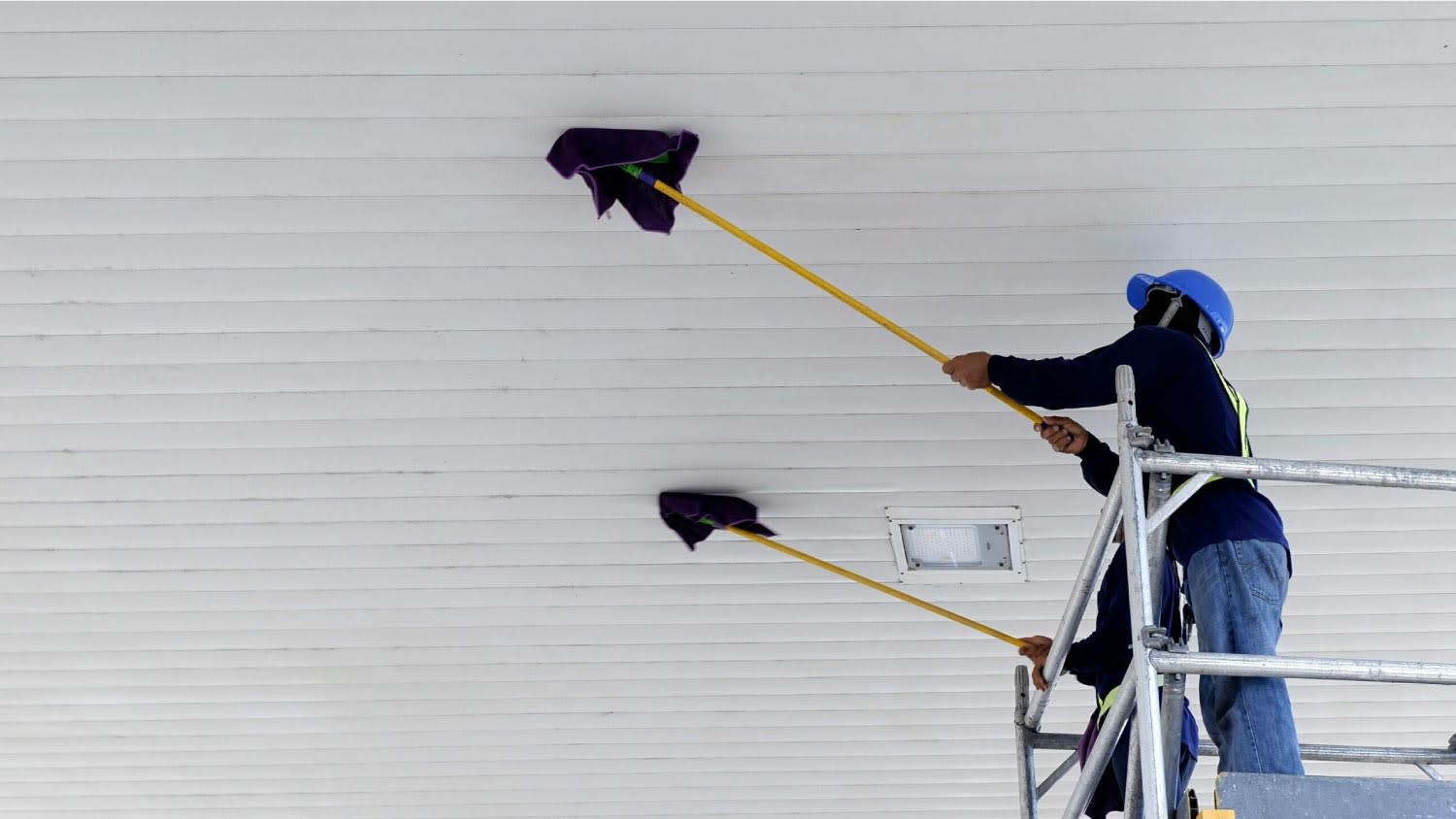 Workers cleaning white ceiling roof