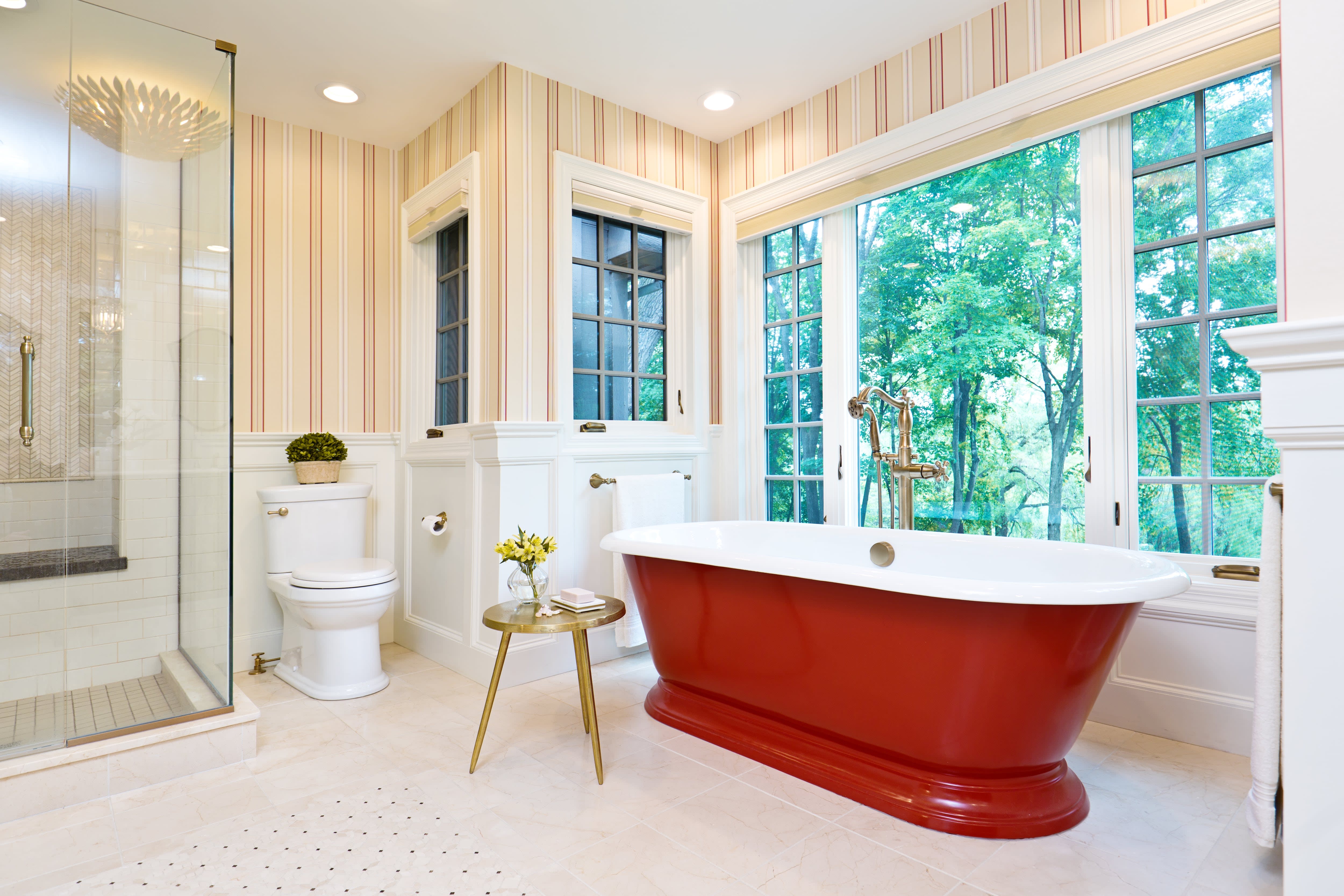 Classic bathroom with striped wallpaper, shower, commode, and freestanding red cast iron bathtub