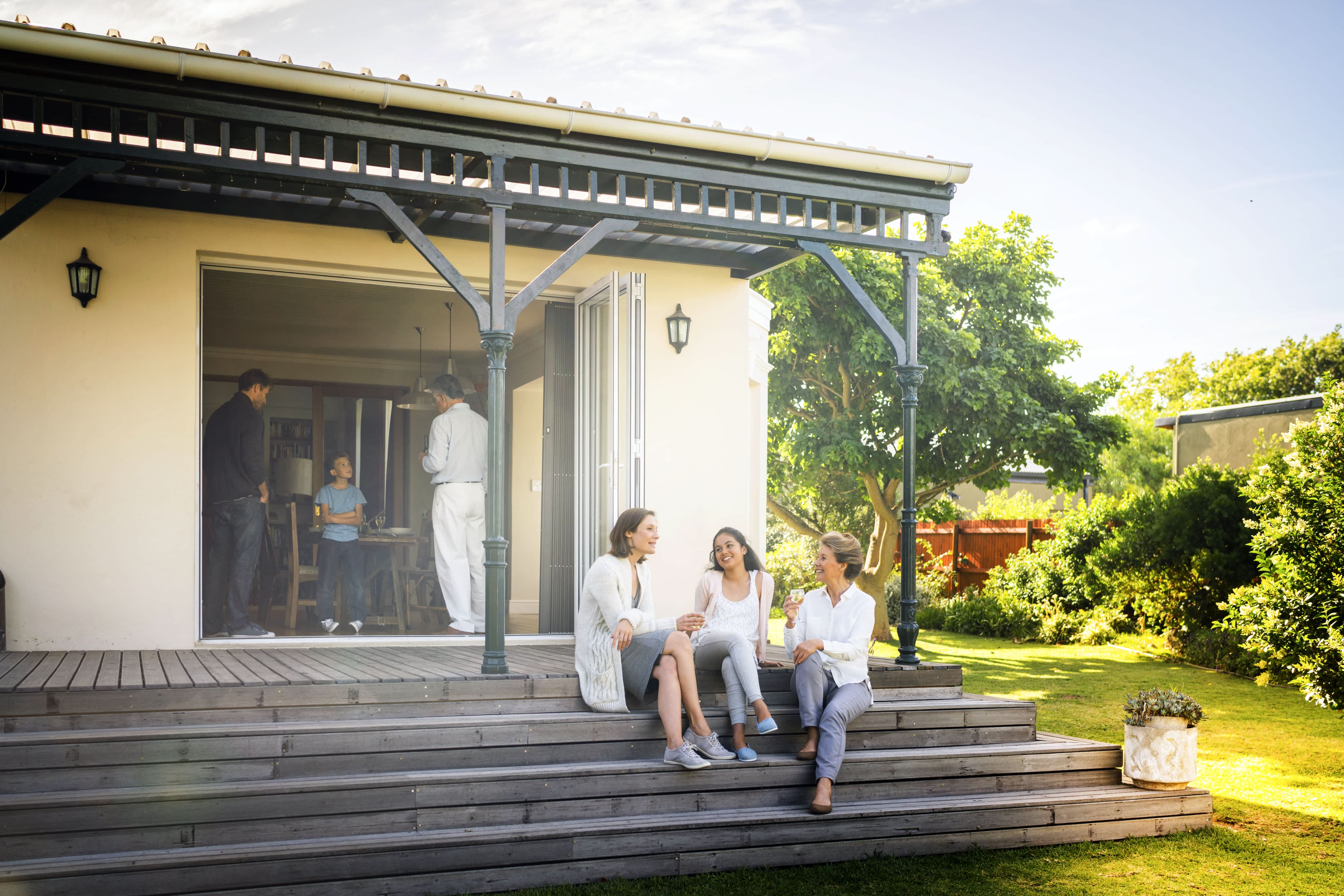 Family relaxing on covered porch with painted beams