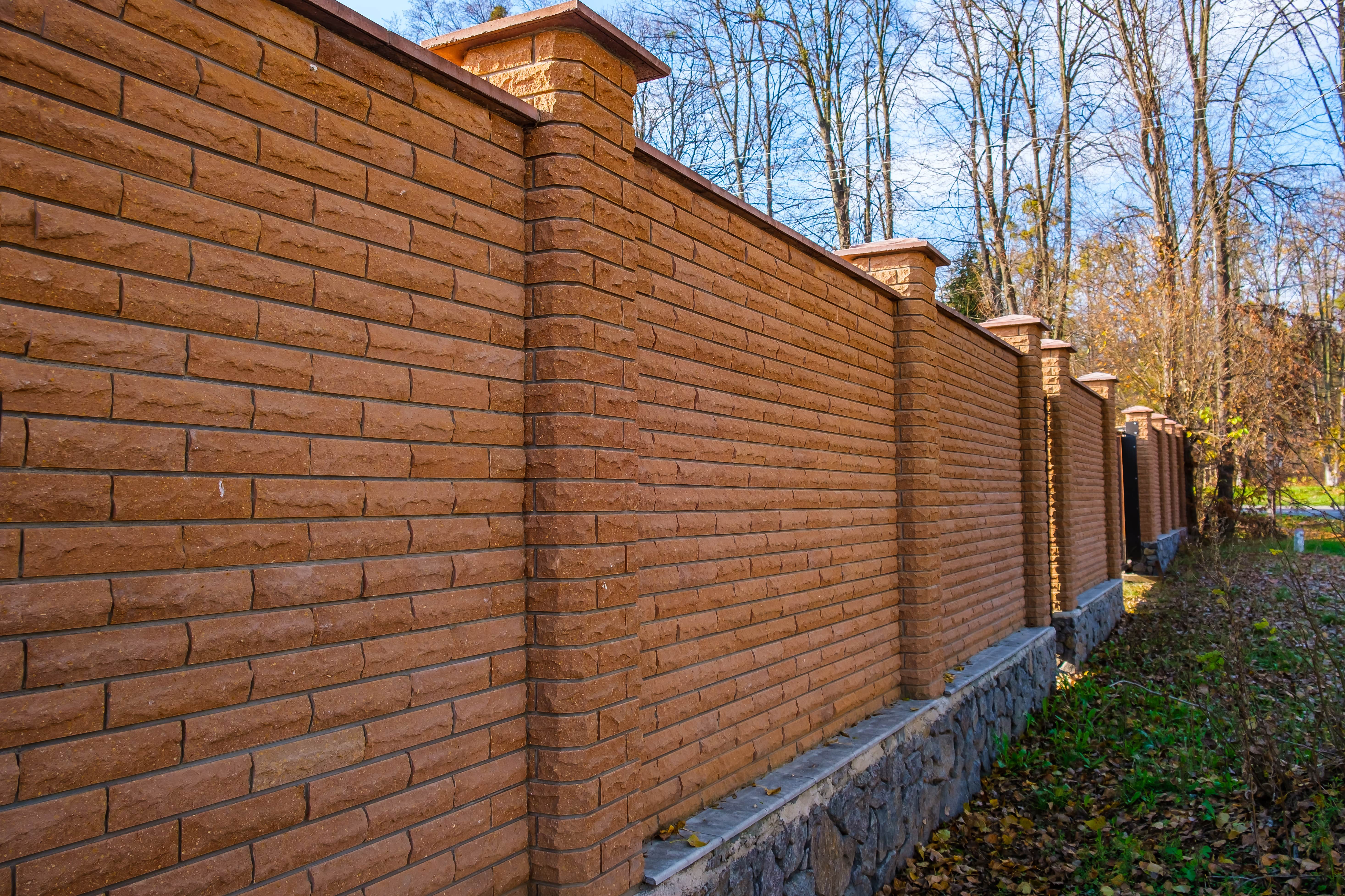 A tall brick fence with columns throughout