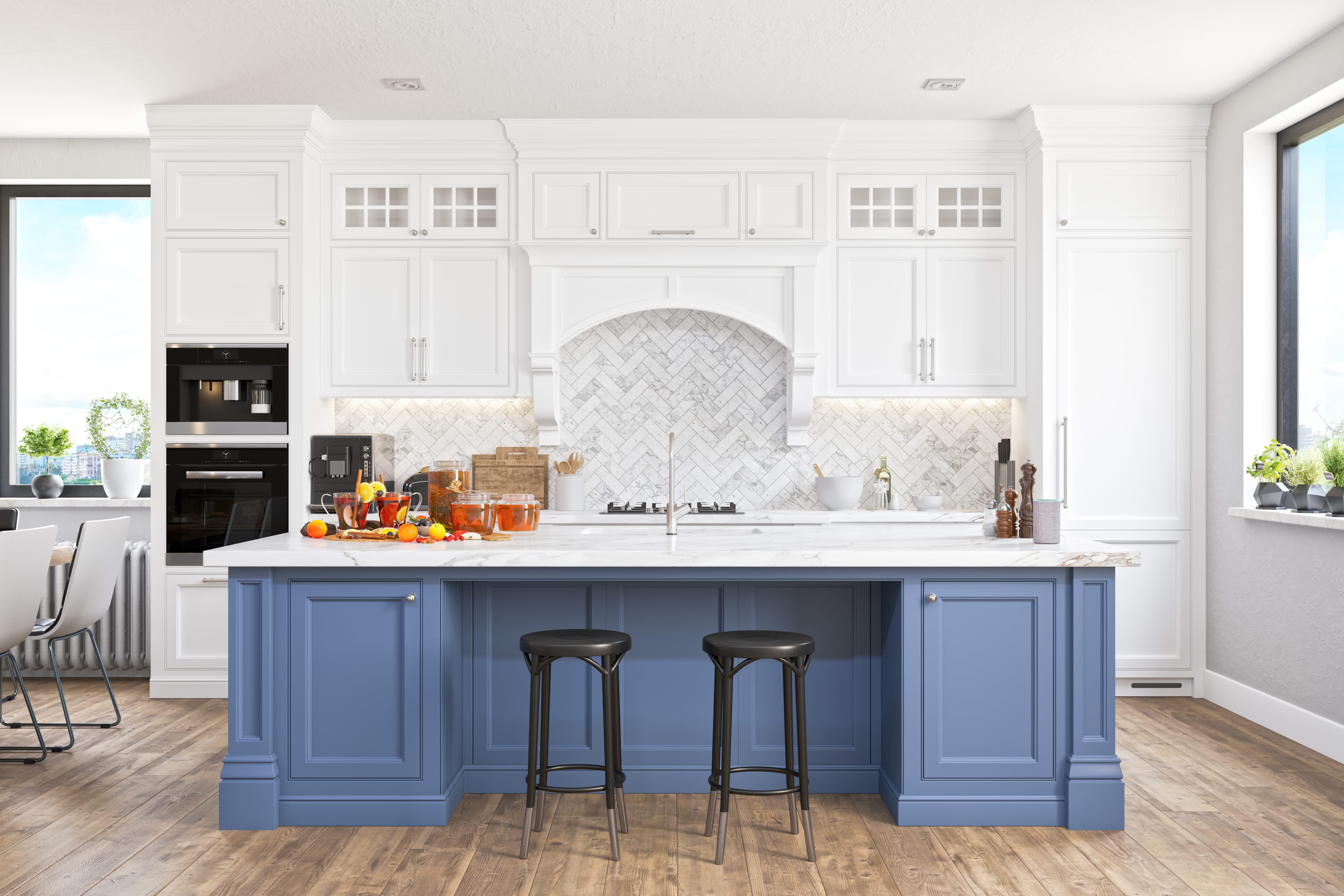 A white kitchen with herringbone backsplash and a blue kitchen island