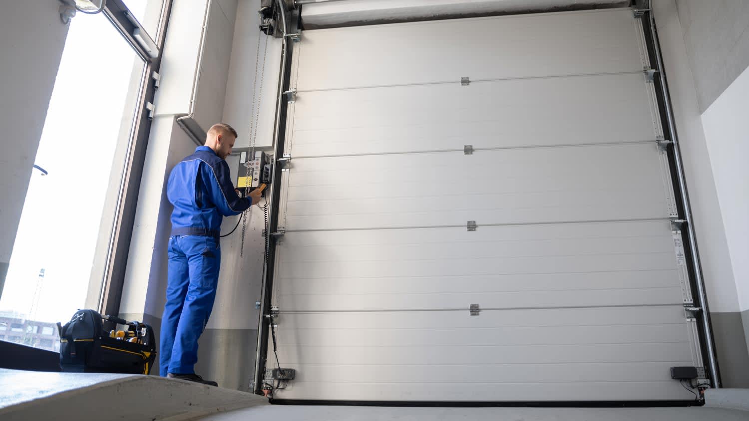 A professional repairing a garage door opener