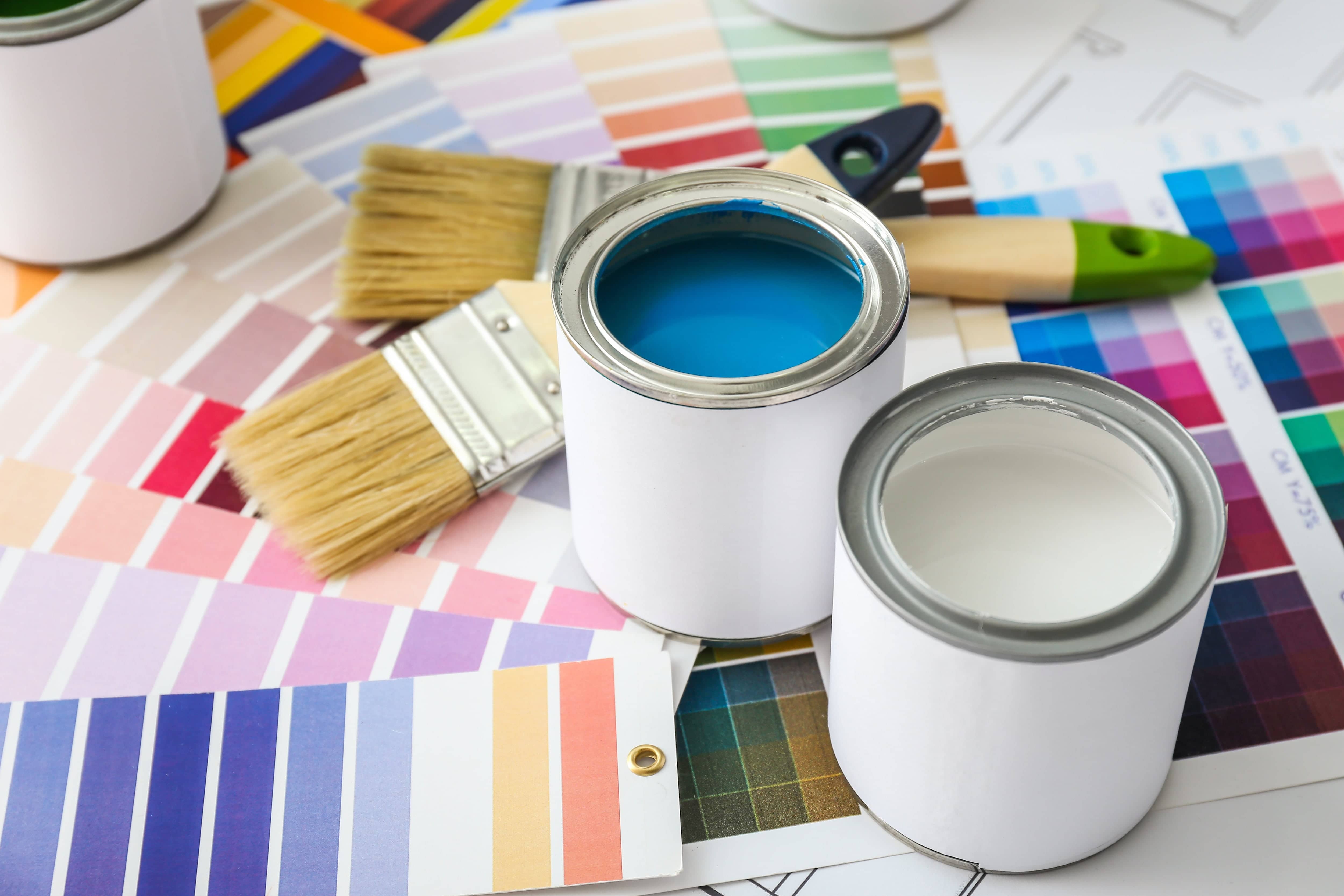 Two paint buckets surrounded by paint sample cards
