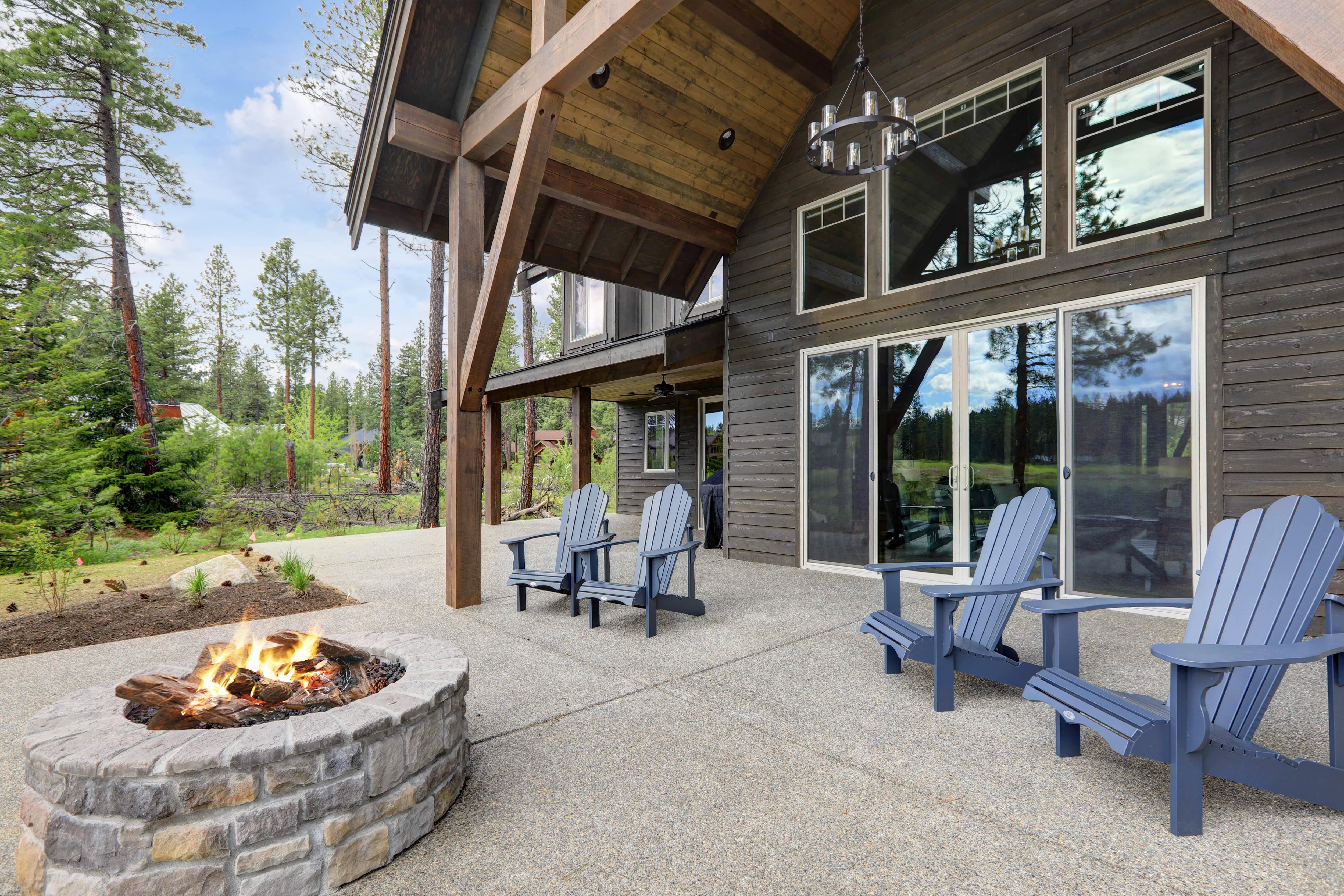 Covered patio with adirondack chairs and stone fire pit