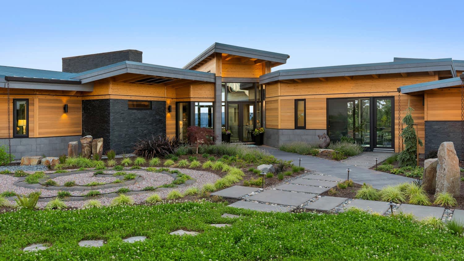 The entrance of a modern house with a landscaped garden