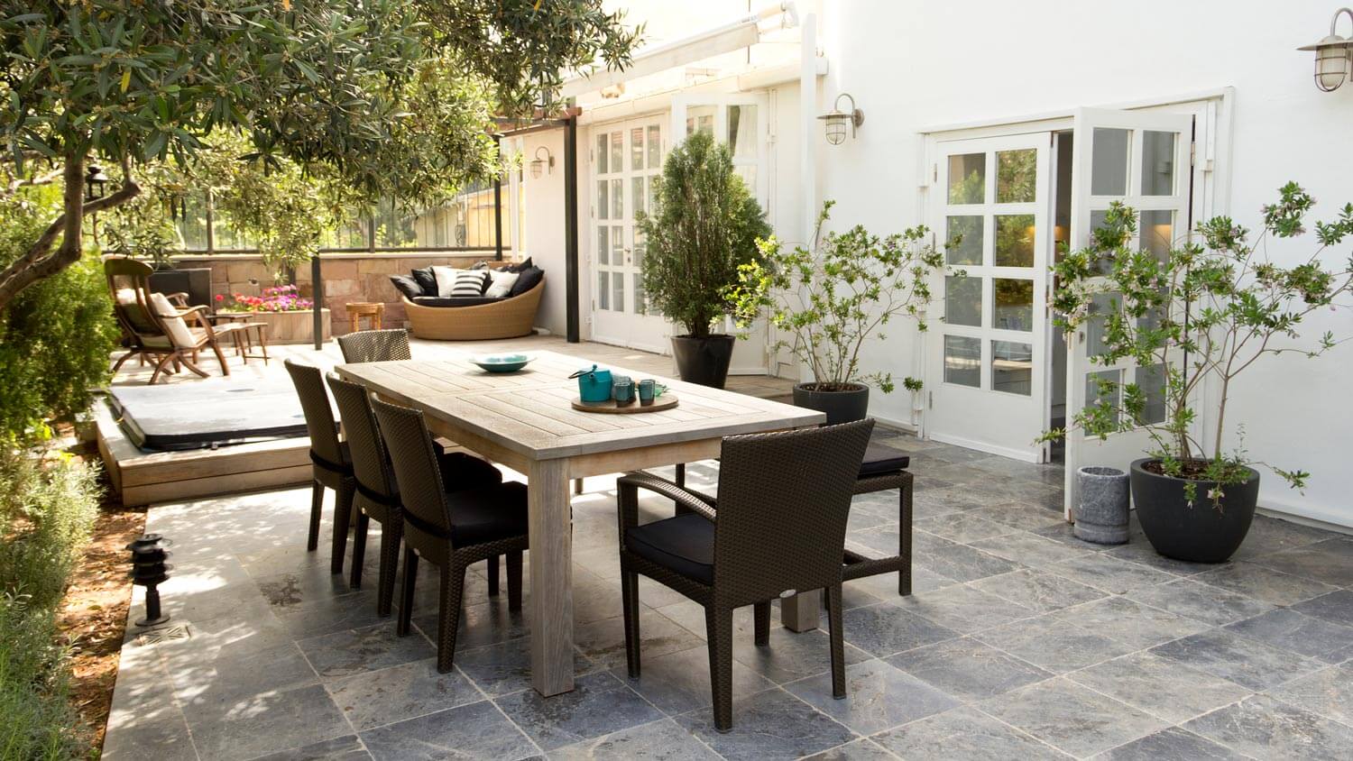 A patio with a dining table in a house’s backyard