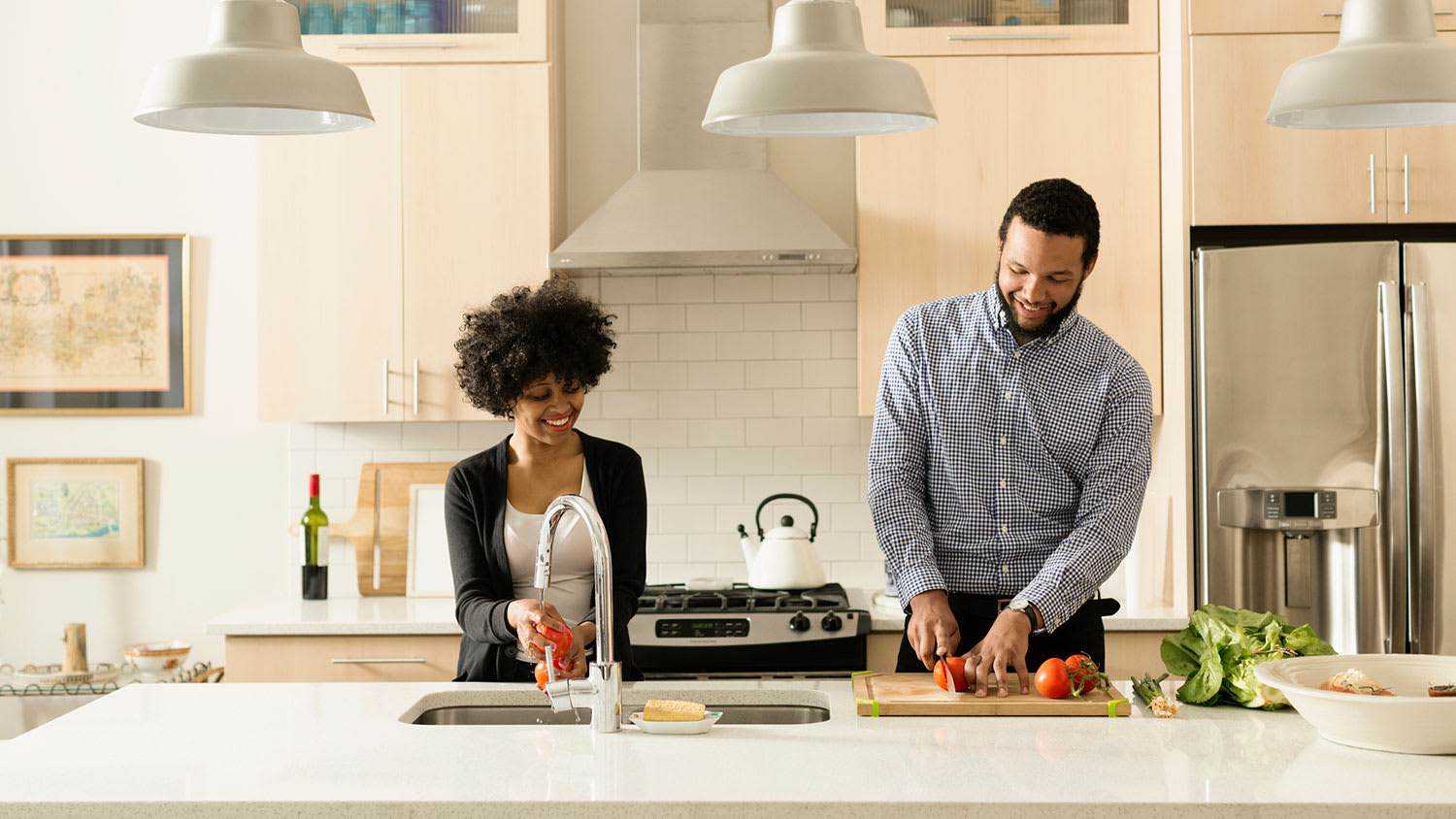Couple in the kitchen washing and chopping veggies