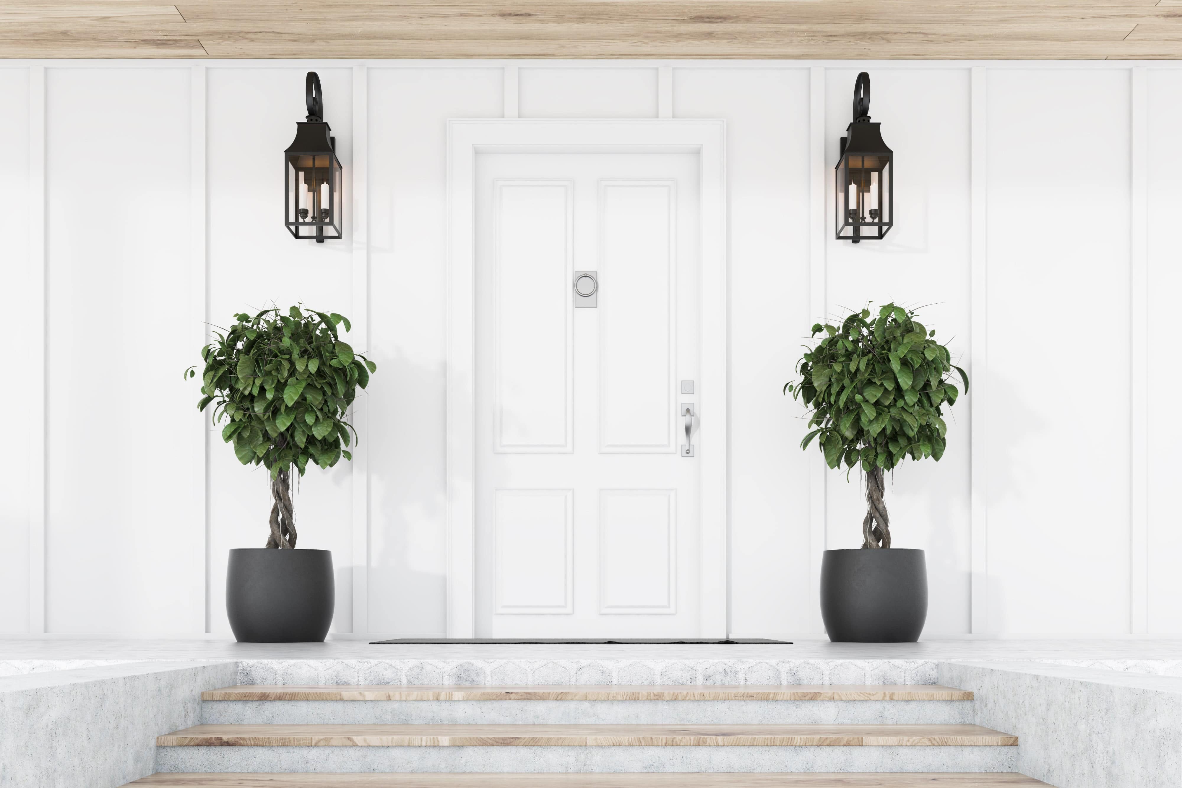 Topiary trees on both sides of the entry door on front porch