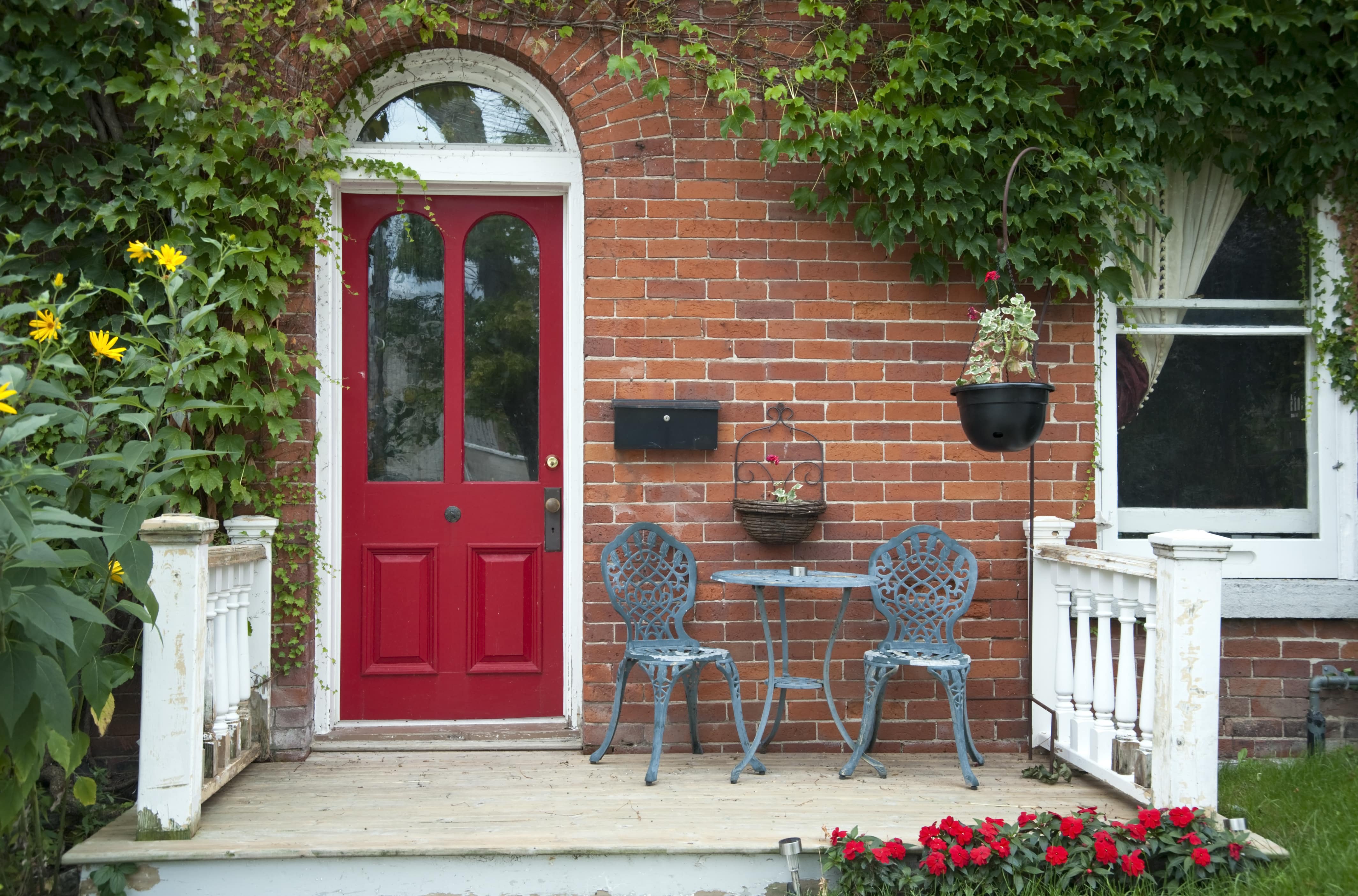 Bistro set on front porch with red entryway door