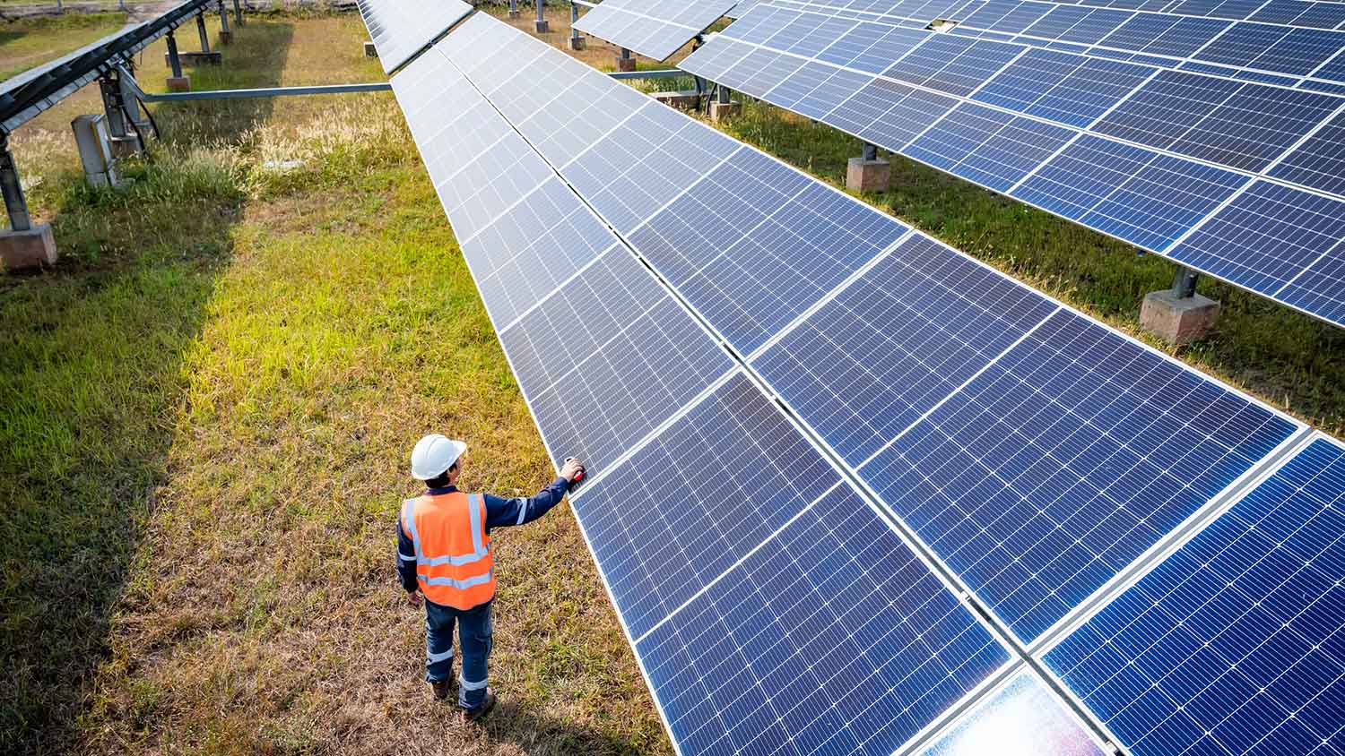Engineer checking photovoltaic solar panels in a solar farm