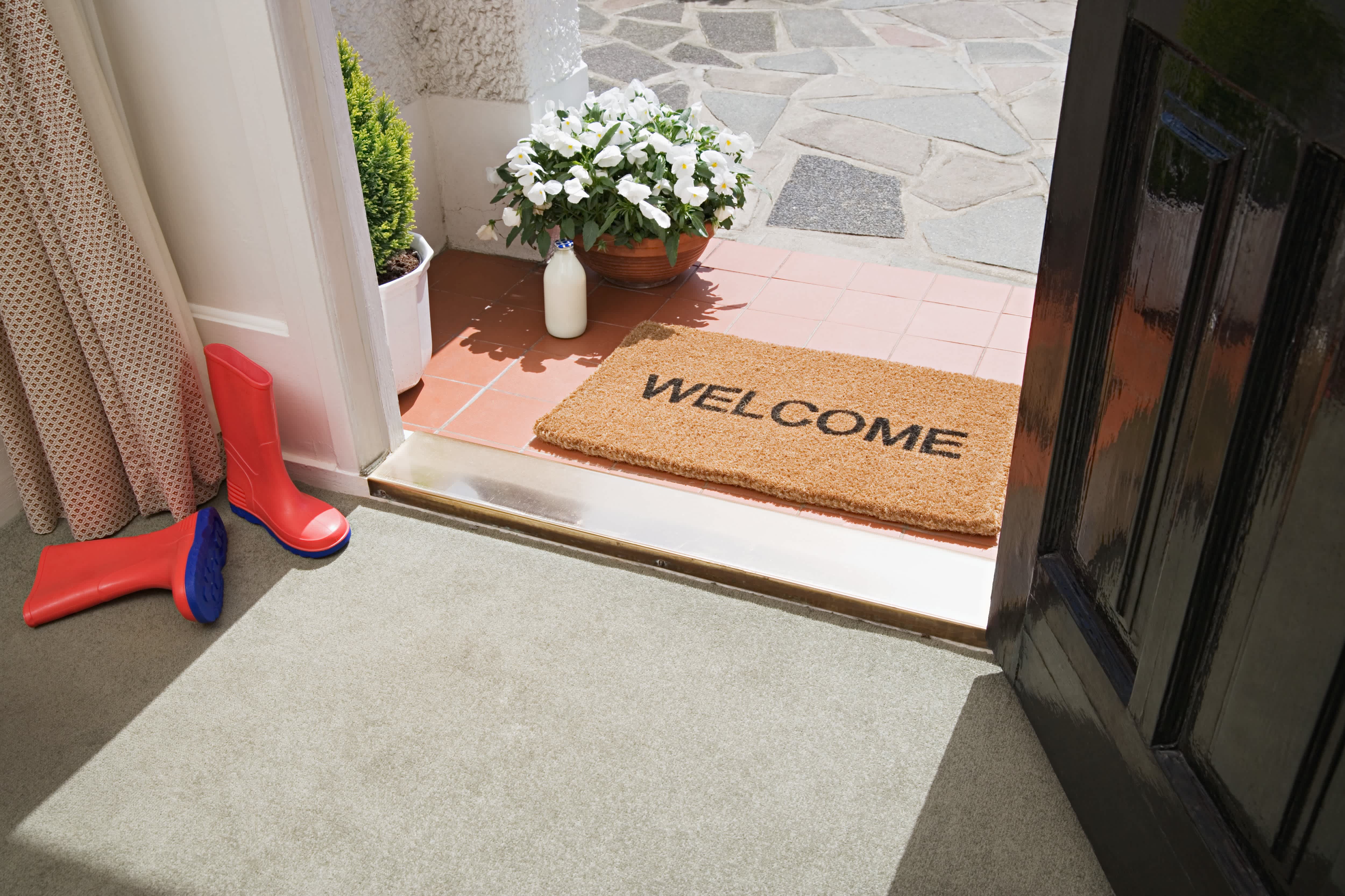 Welcome mat on front porch in front of entryway door