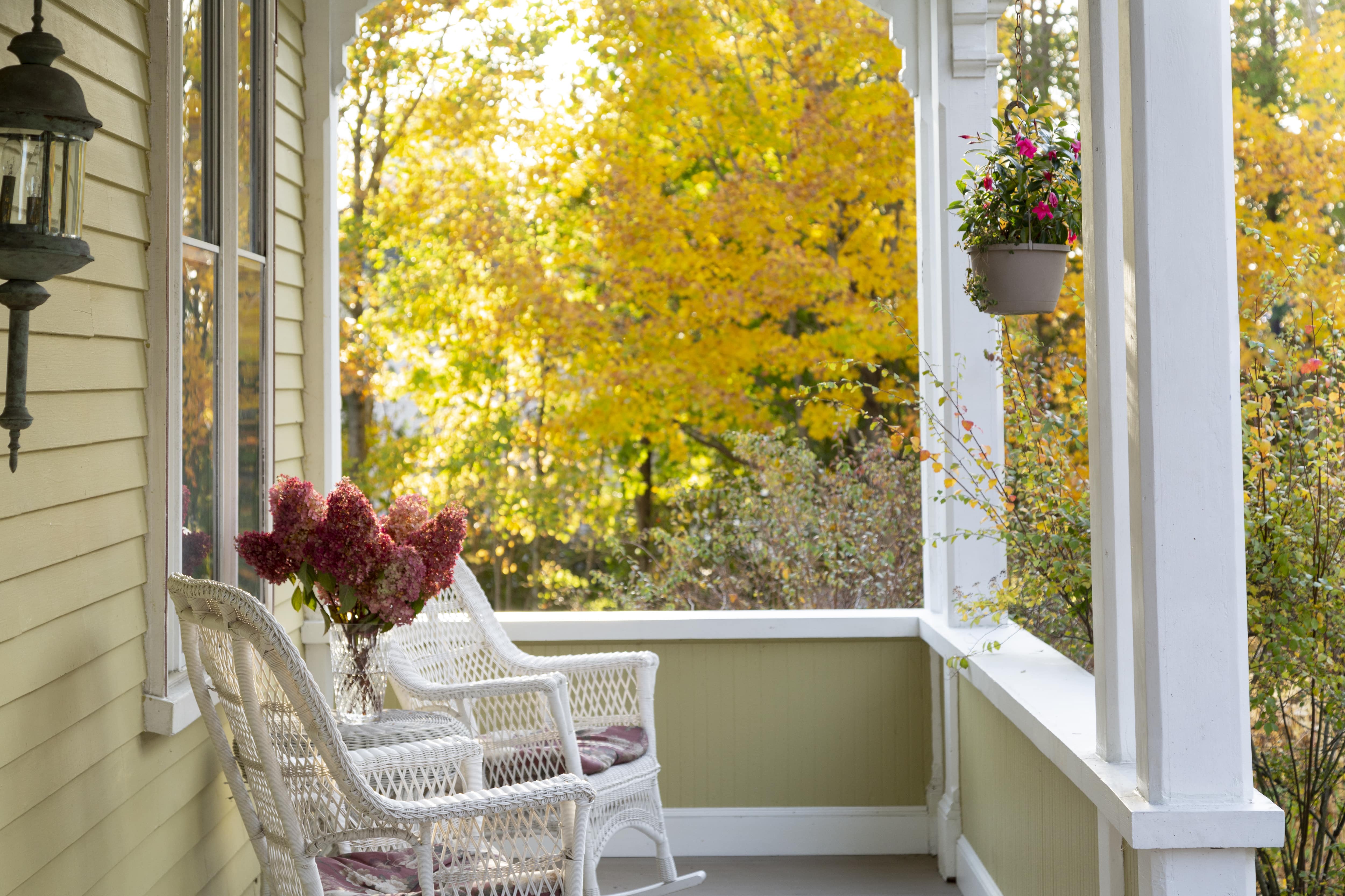 Front porch with wicker rocking chairs and glass flower vase