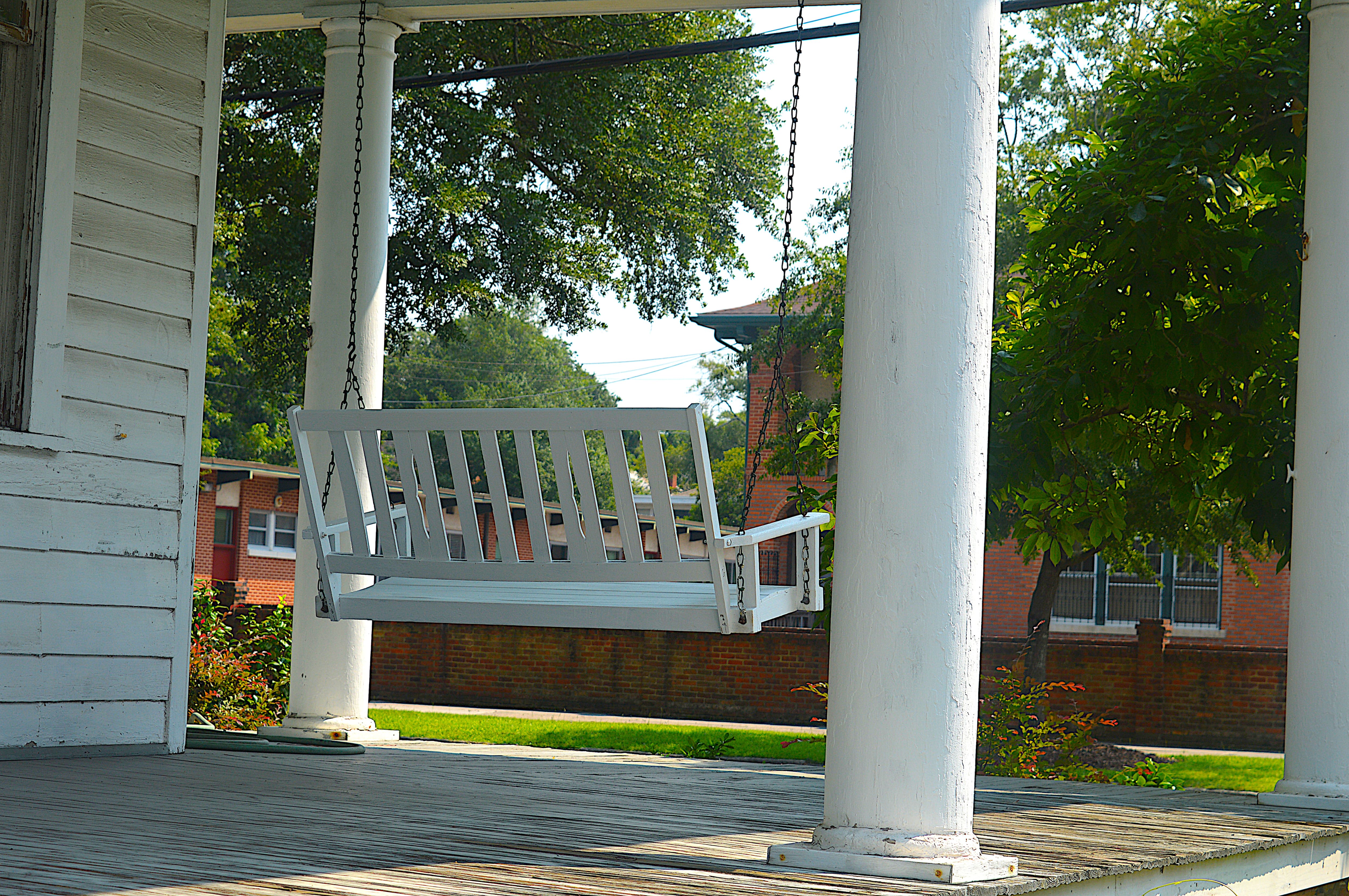 Porch swing hung from covered front porch overhang