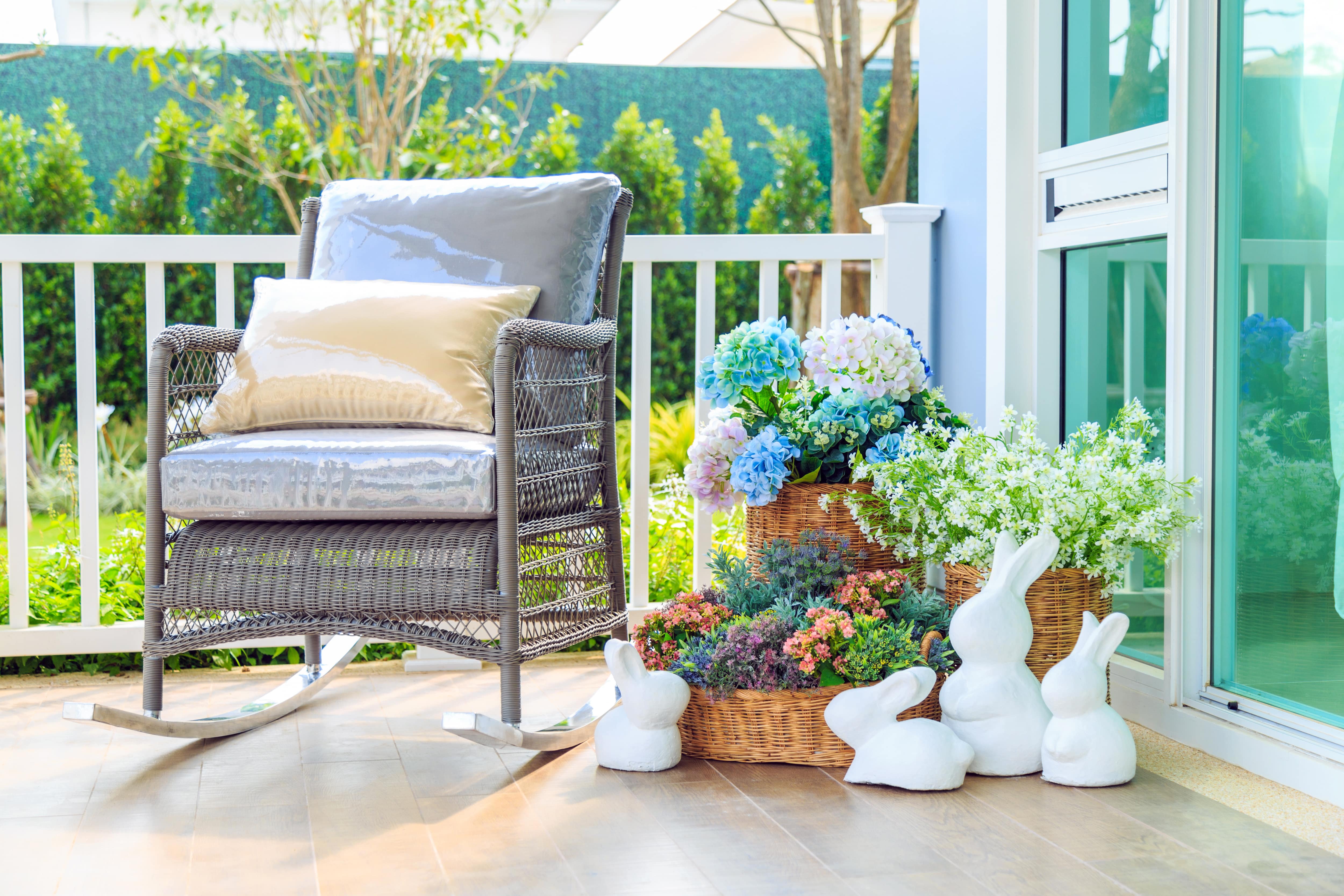 Rock garden statues in front of floral arrangement on front porch