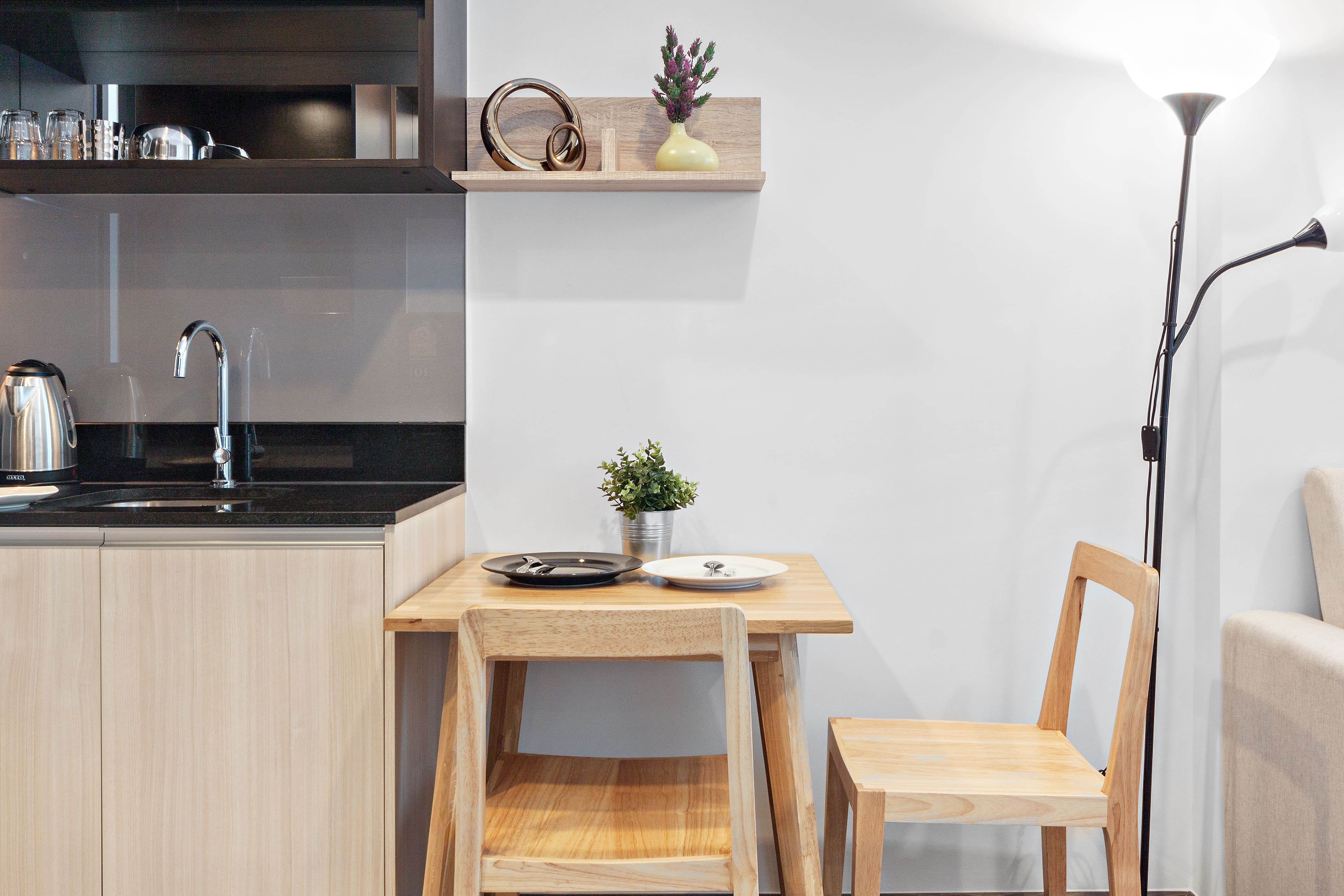 A small modern kitchen with a corner table and two chairs