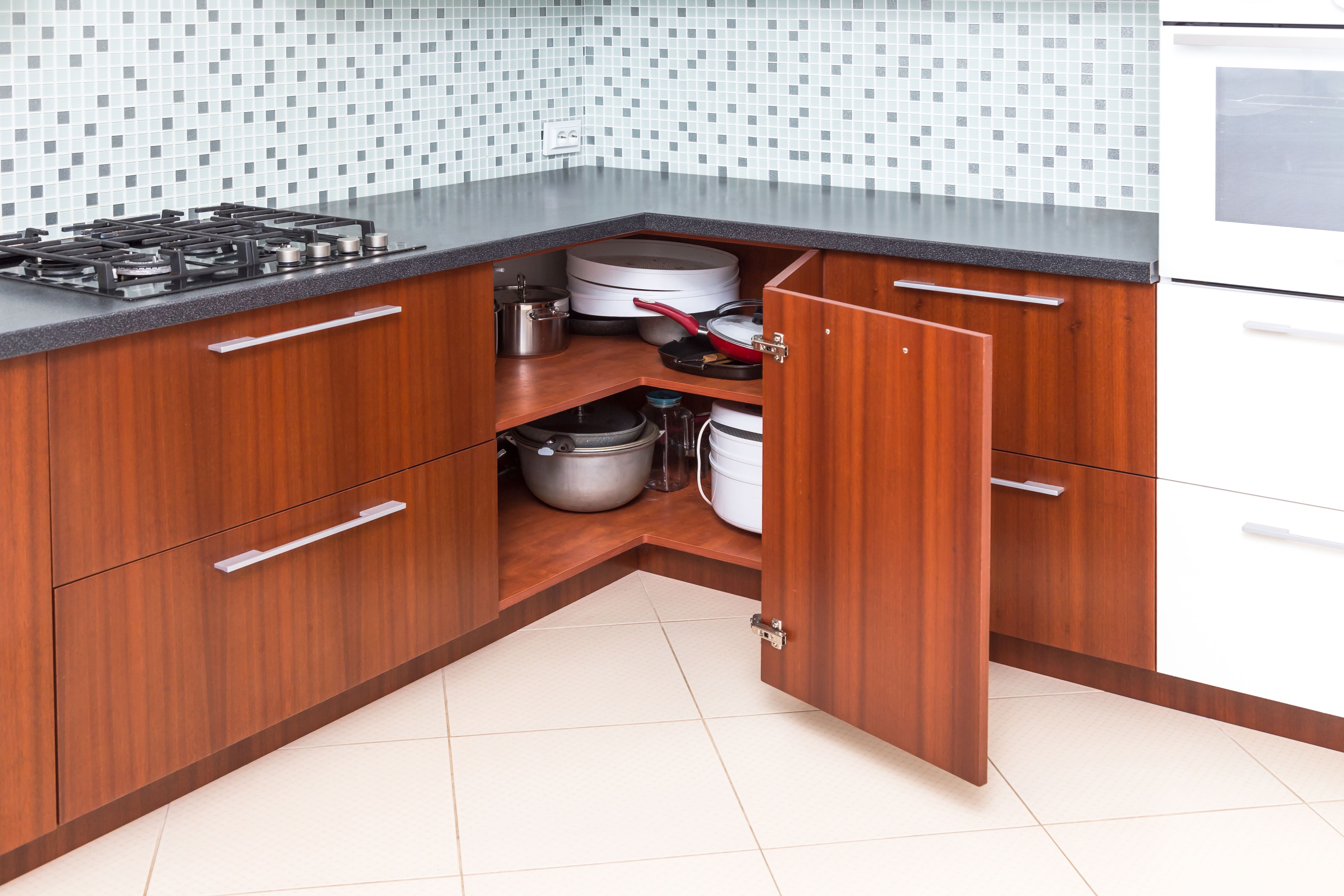 A hinged corner cabinet allowing access to storage shelves