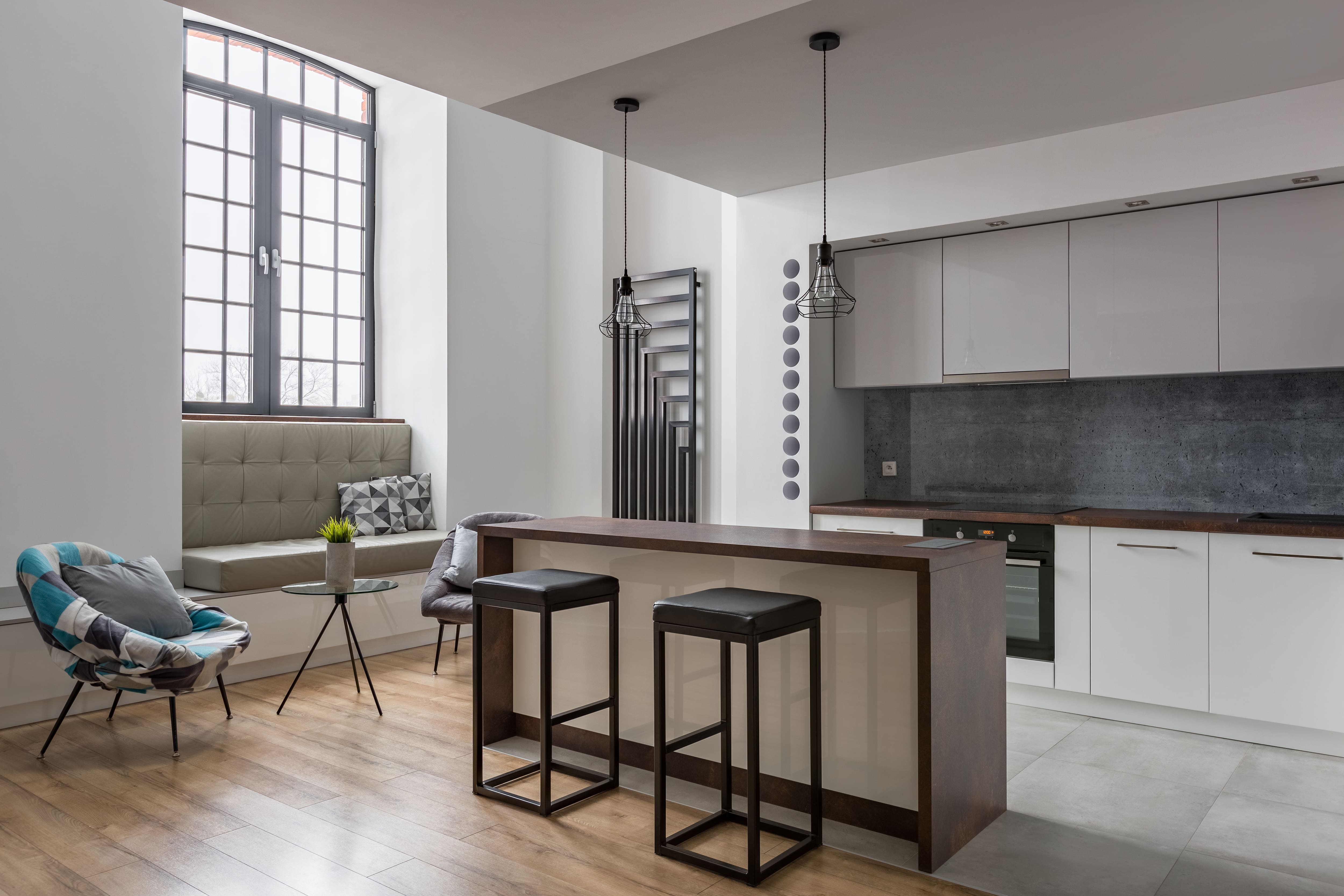 A slim kitchen Island with two stools in a gray kitchen