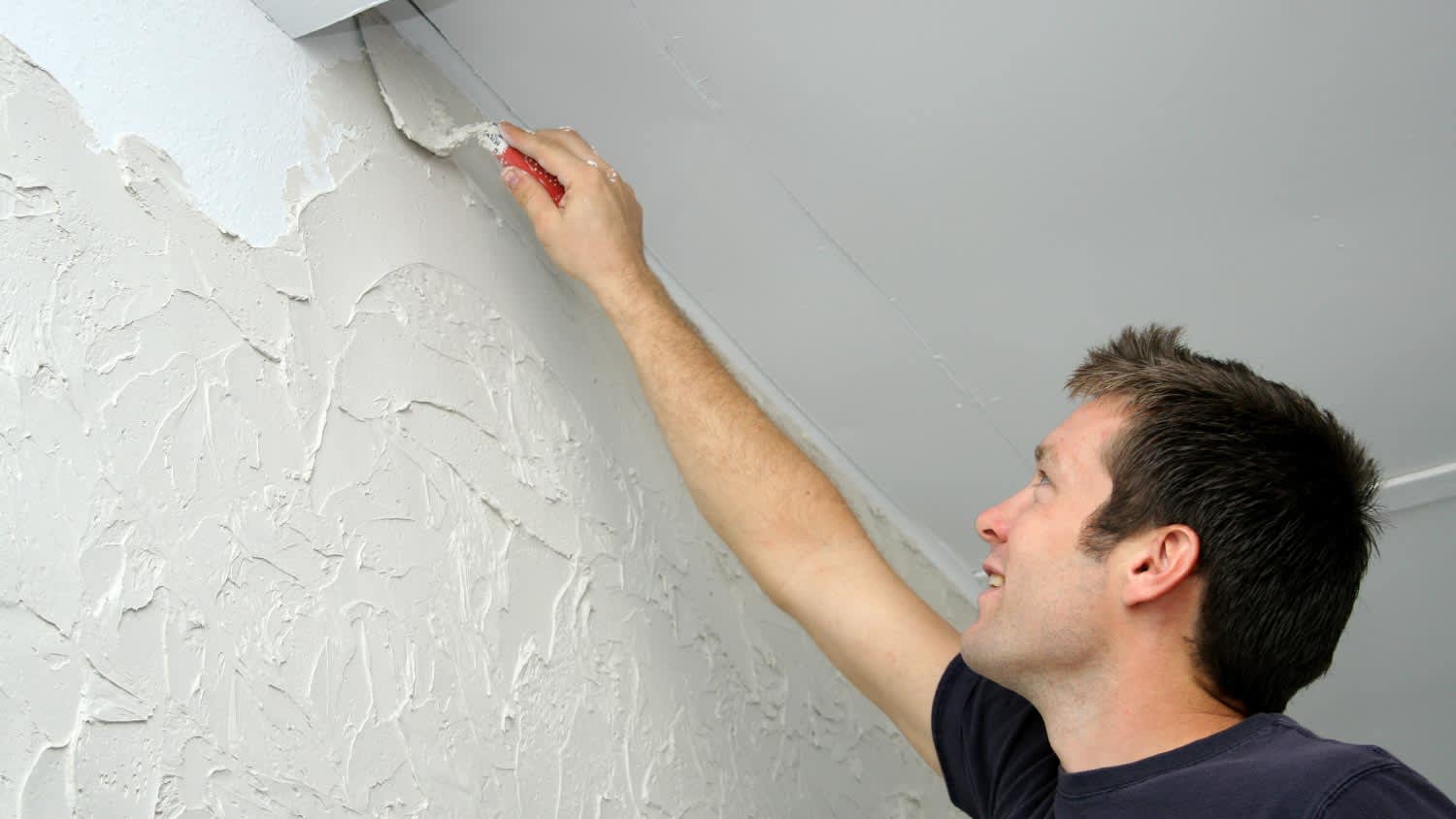 A man texturizing wall