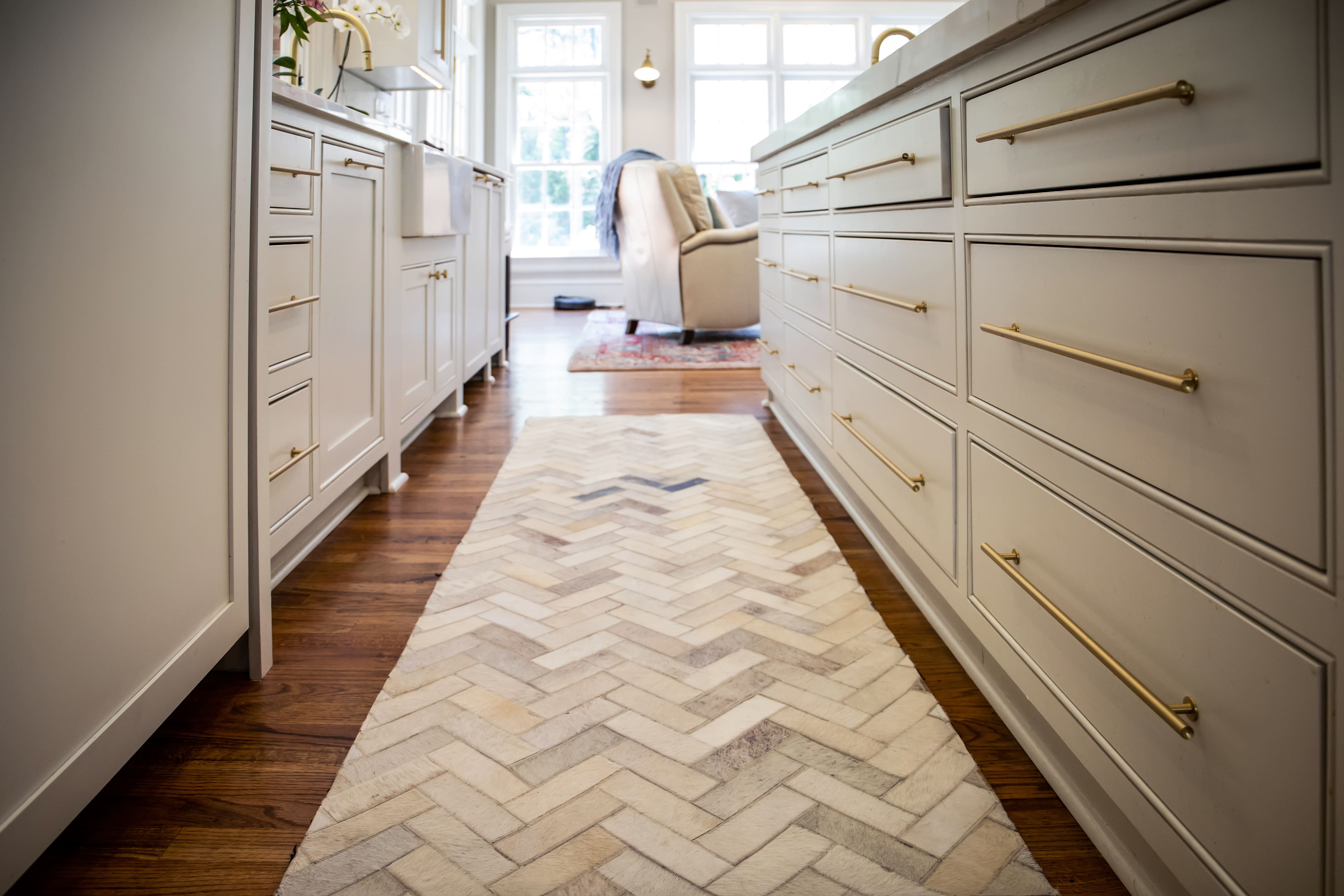 A galley kitchen with a herringbone runner rug