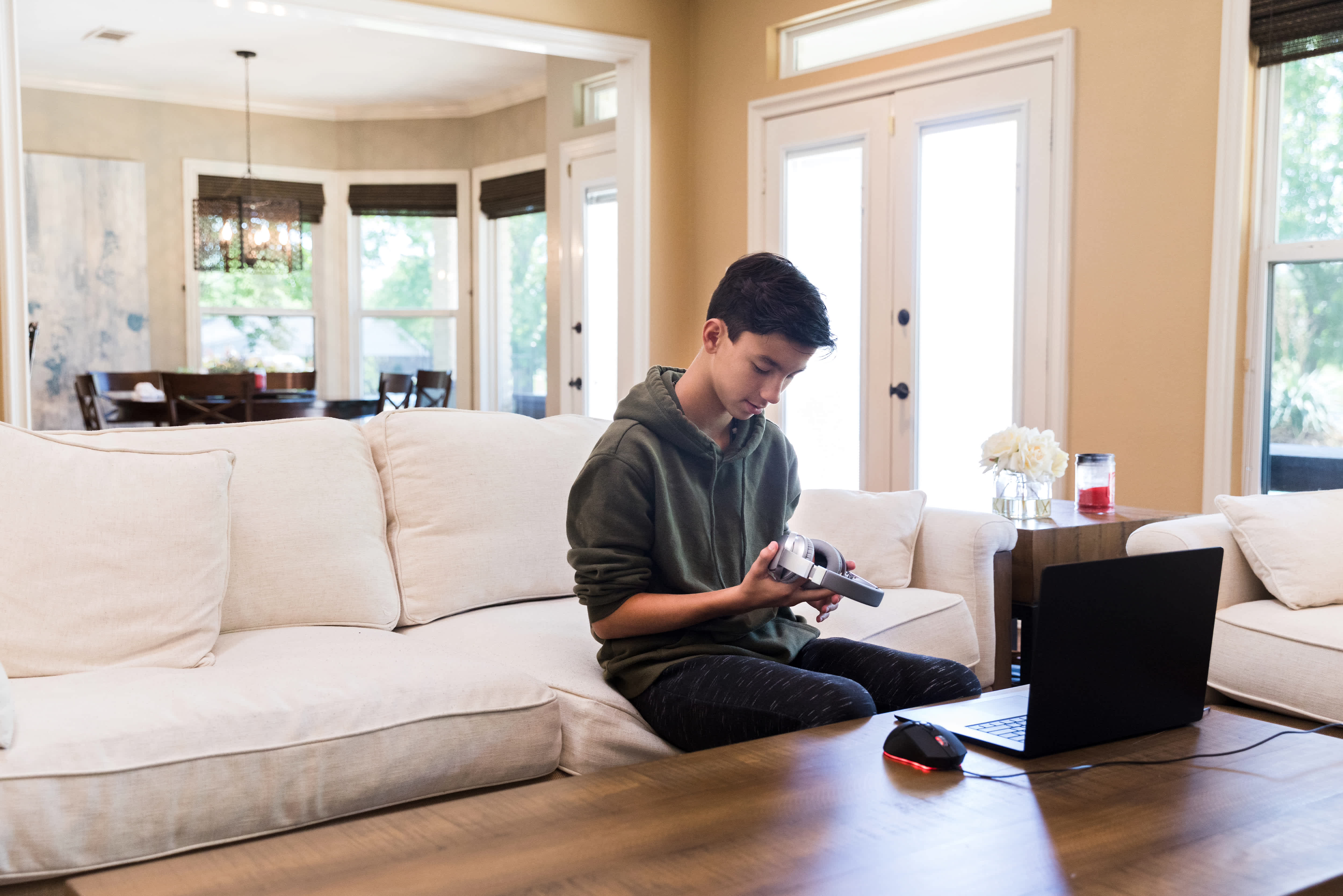 A young boy setting up headphones in a room filled with crown molding pieces