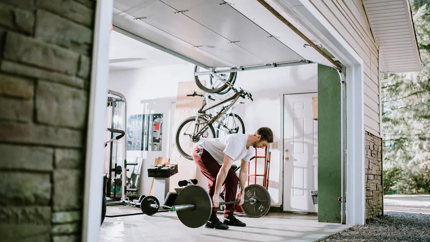 A man exercises in garage turned into home gym