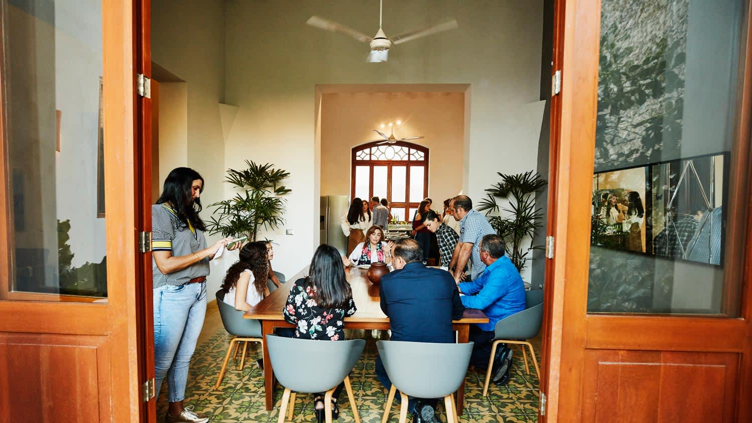 A family having a dinner in a dining room with a ceiling fan