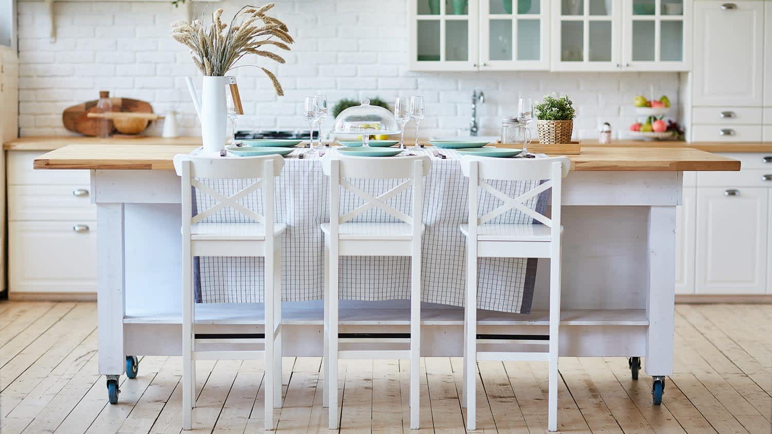 Beautiful white kitchen with butcher block island on wheels