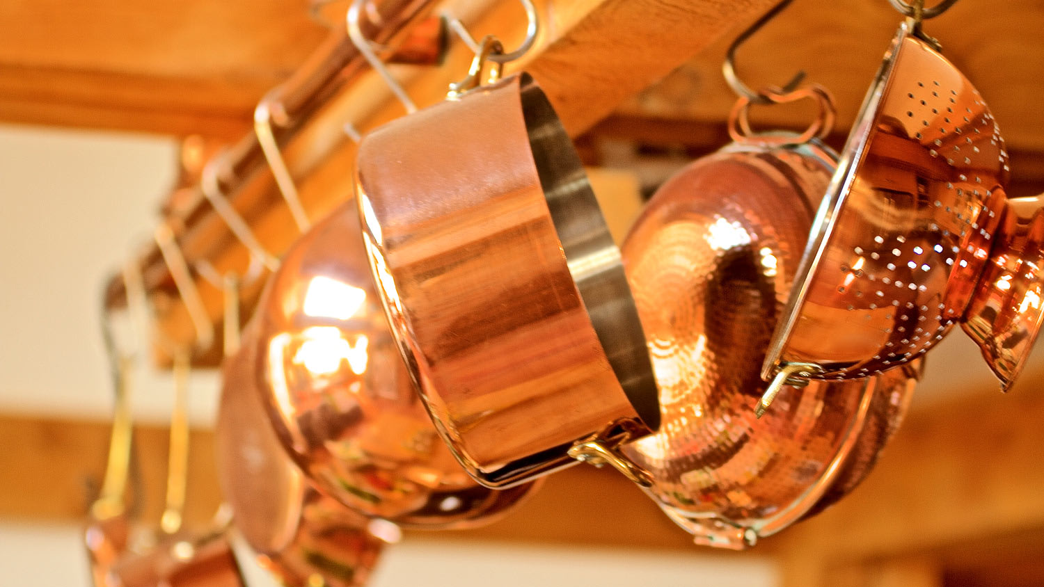 Copper pots hanging in the kitchen in a row