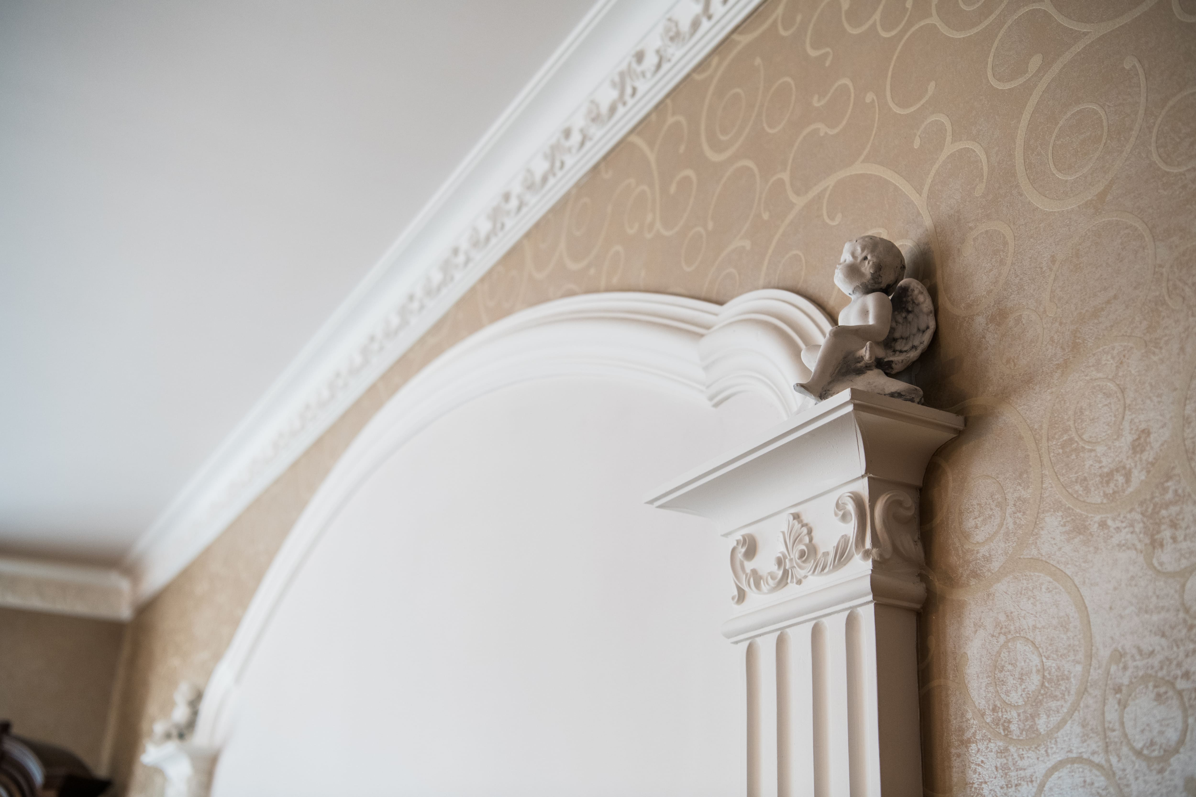 An intricately patterned crown molding overtop wallpaper