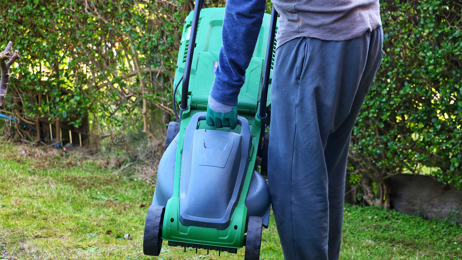 man carrying lawn mower