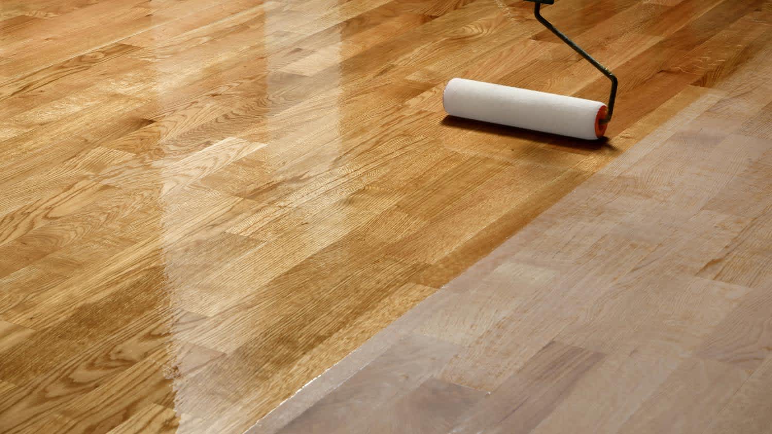 Worker coating wooden floor