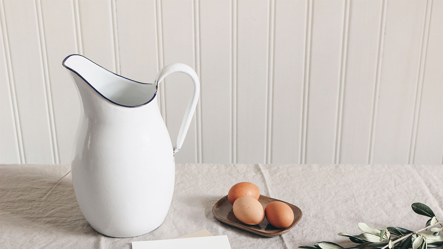 A view of pitcher and eggs with beadboard in the background