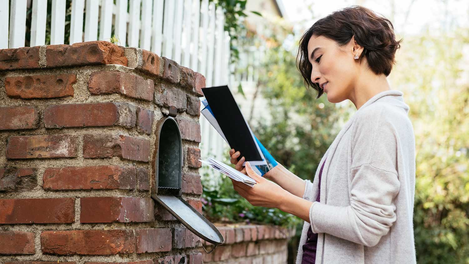 Woman checking mailbox outside of her home