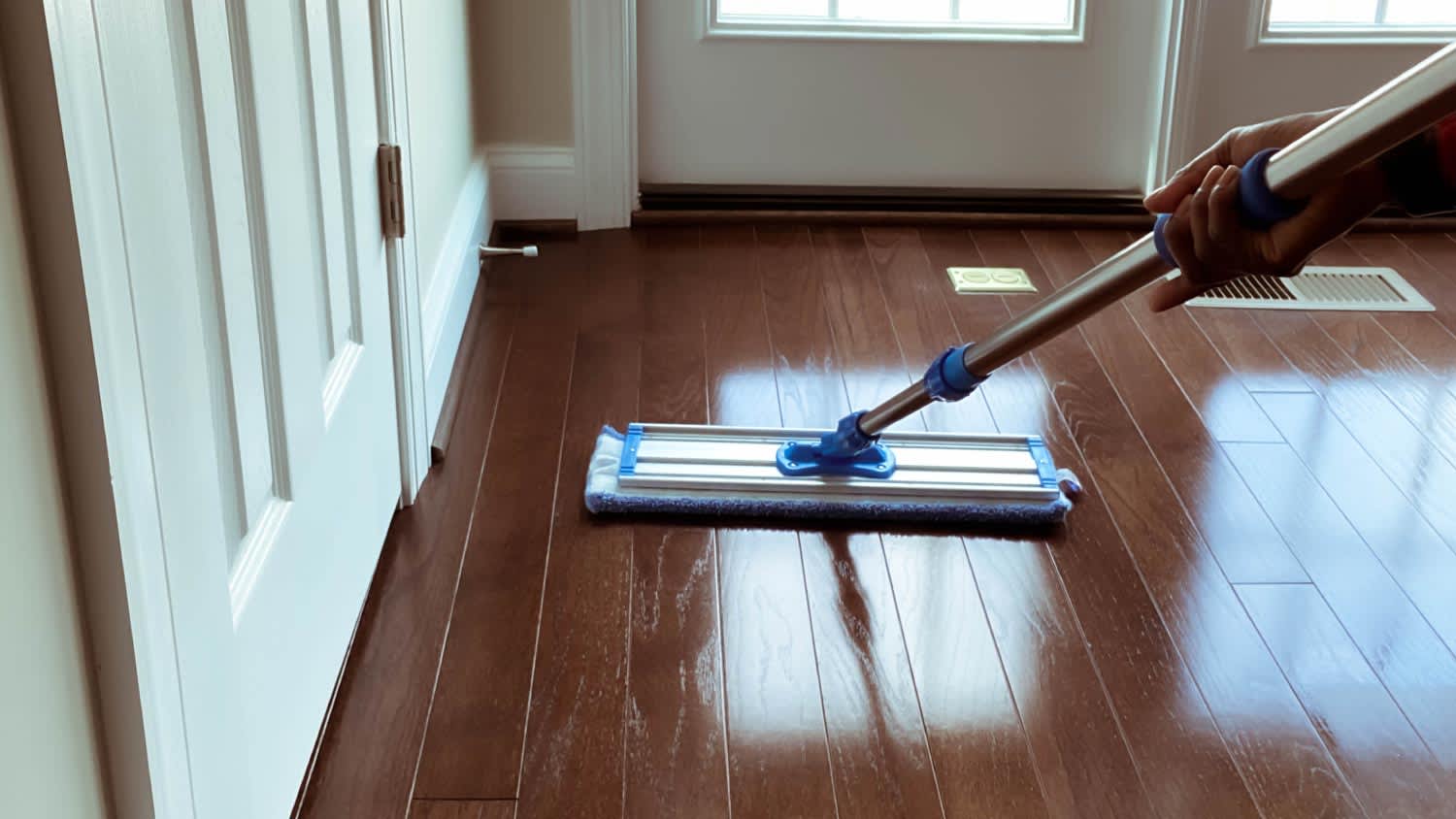 Woman mopping corner of hardwood floor