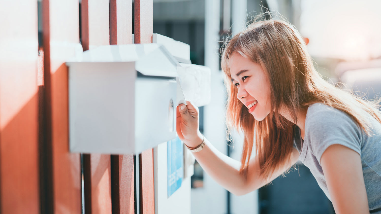 A young woman checking her mailbox