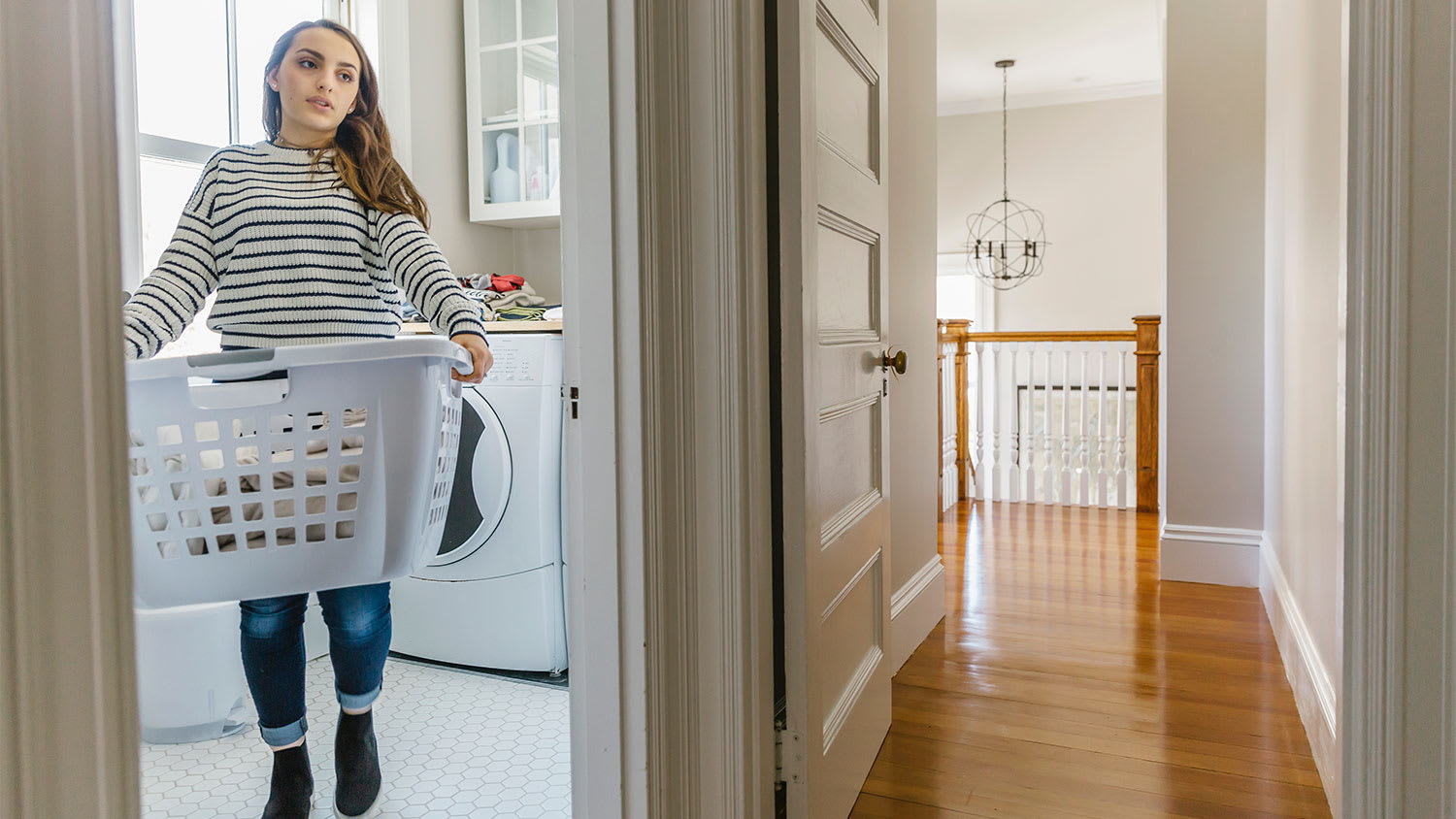 Girl carrying laundry basket upstairs