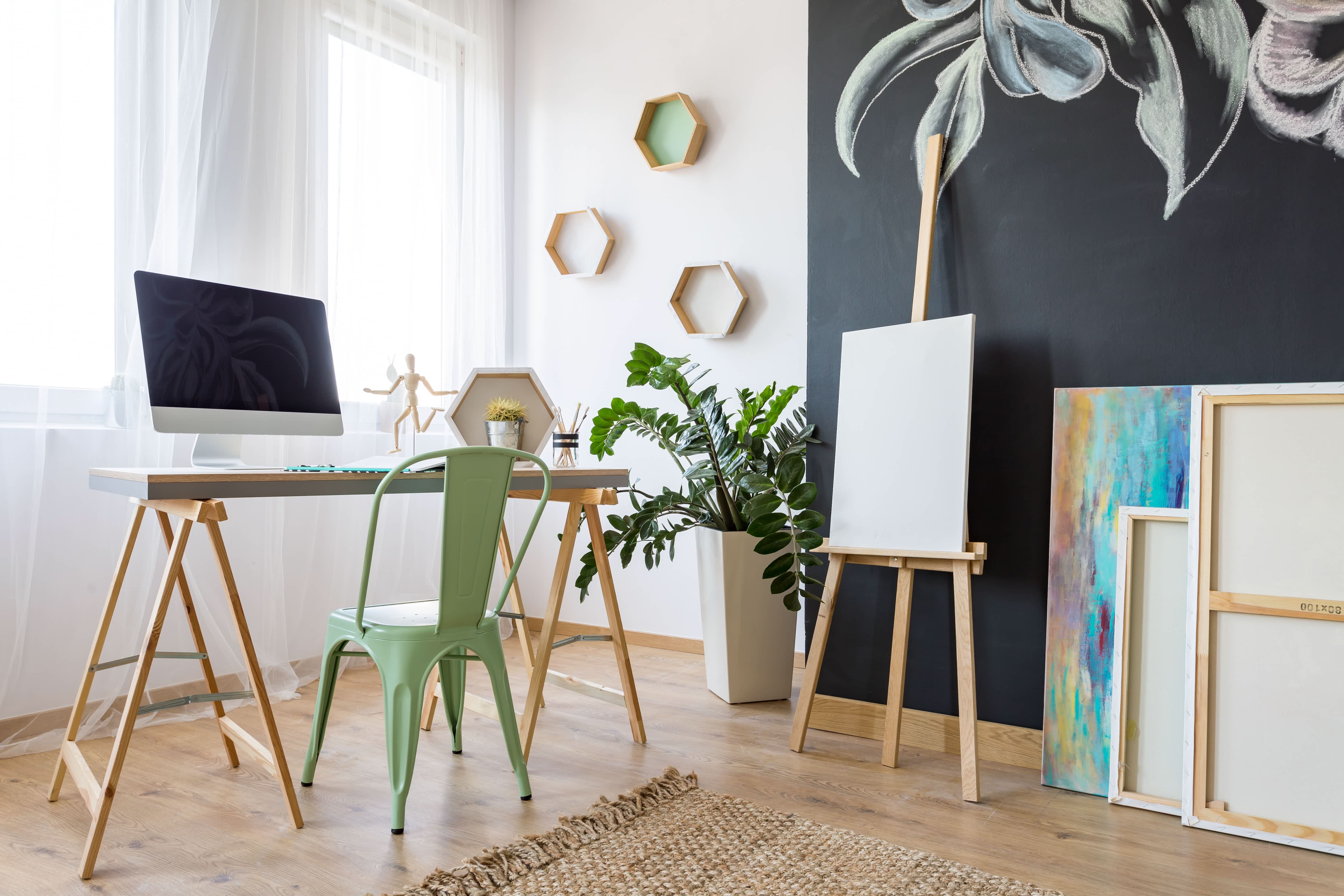 Home office and craft room with desk, computer, chalkboard wall, canvases, and easel