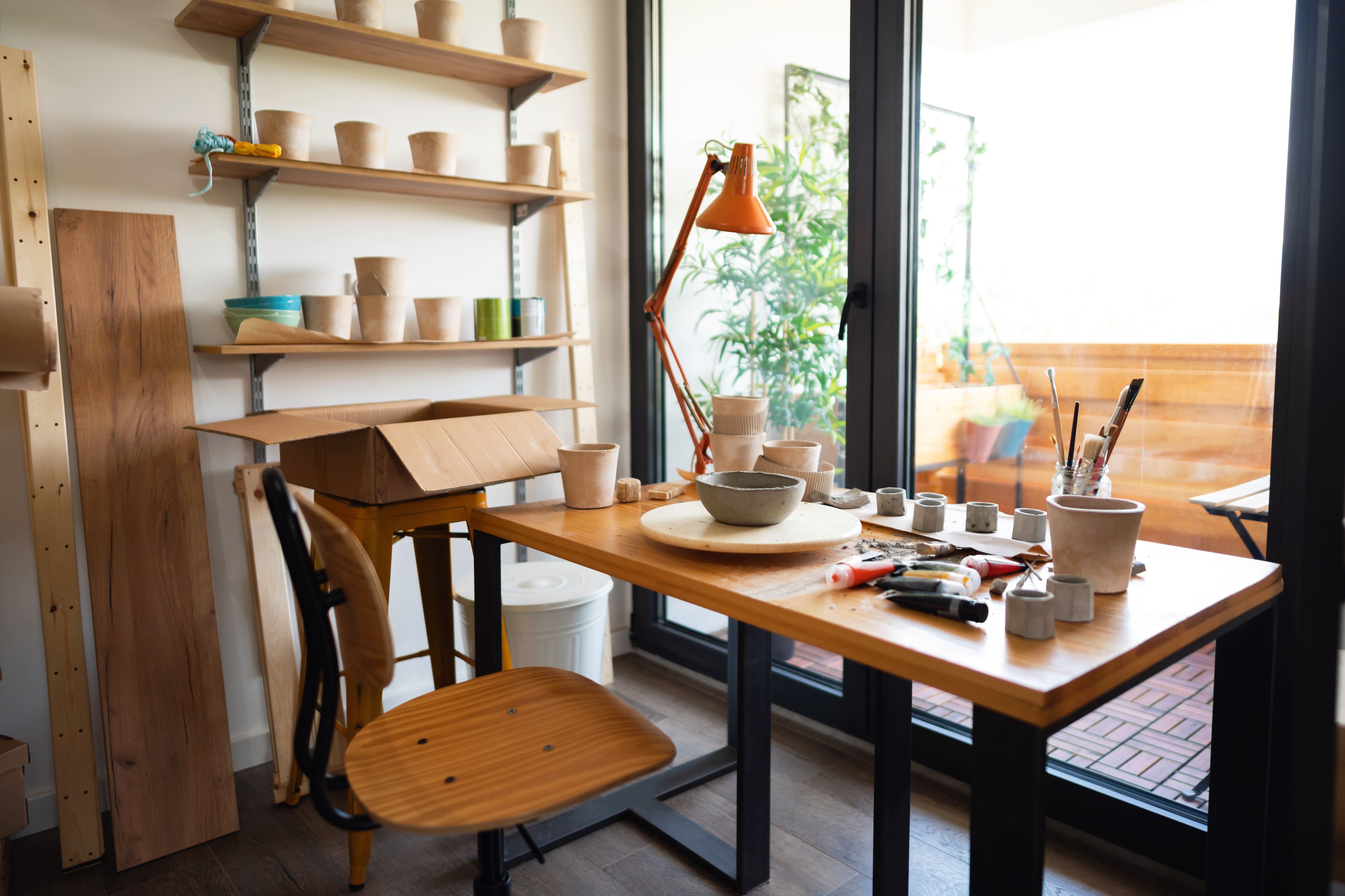 Craft room with floating shelves, desk, chair, light, and windows